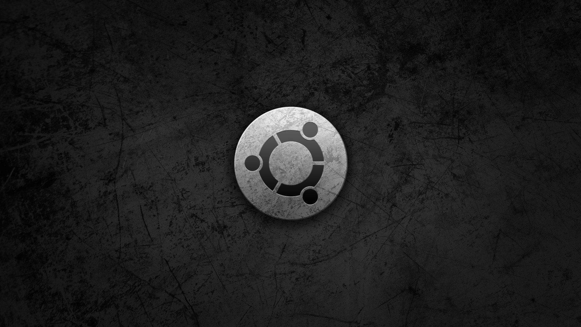 ubuntu 桌布 壁紙 — Ubuntu 標誌居中於帶有金屬光澤的深色粗糙紋理背景上。