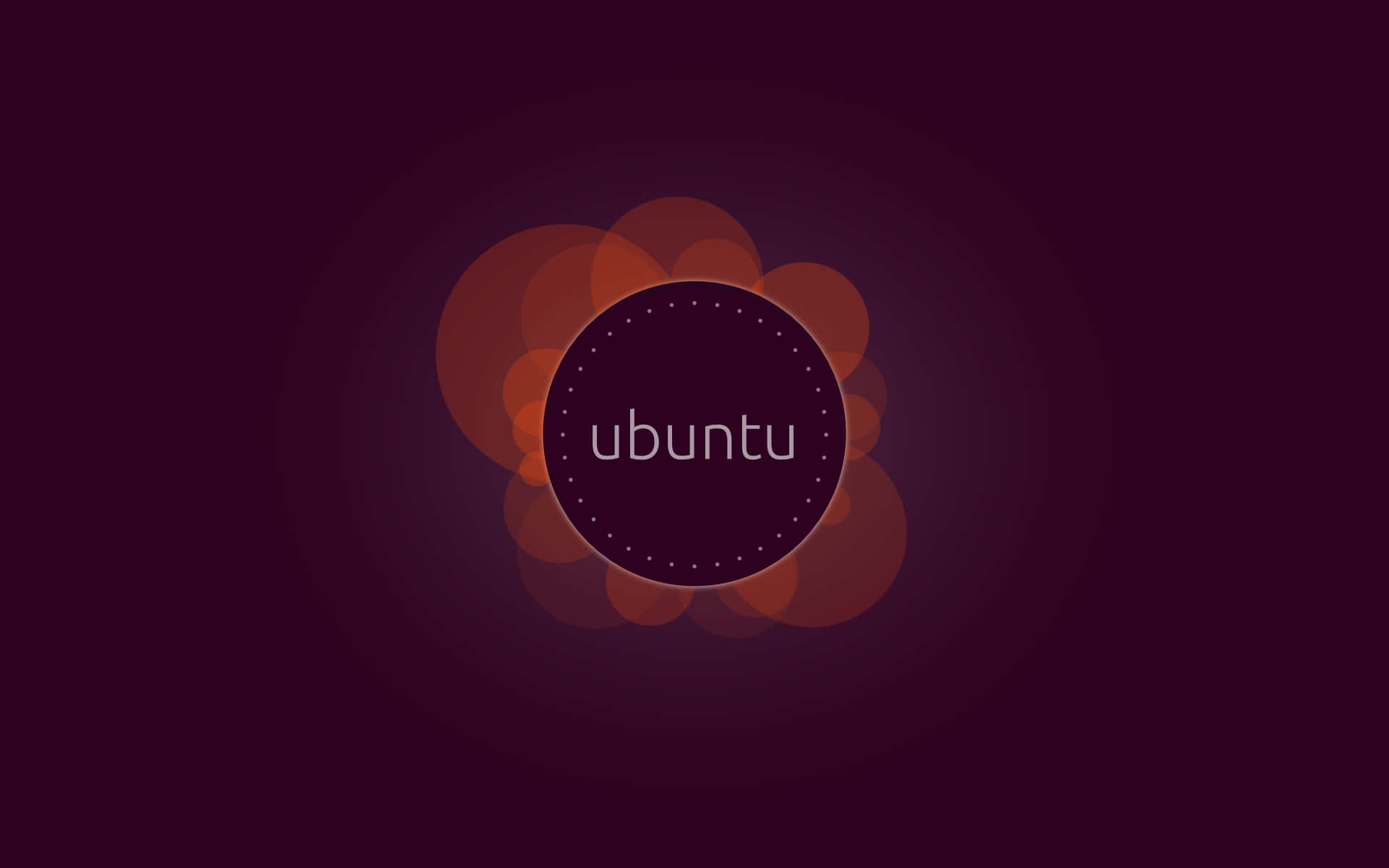 ubuntu 桌布 壁紙 — Ubuntu 標誌居中於深紫色背景，帶有向外輻射的發光橙色散景圓圈。