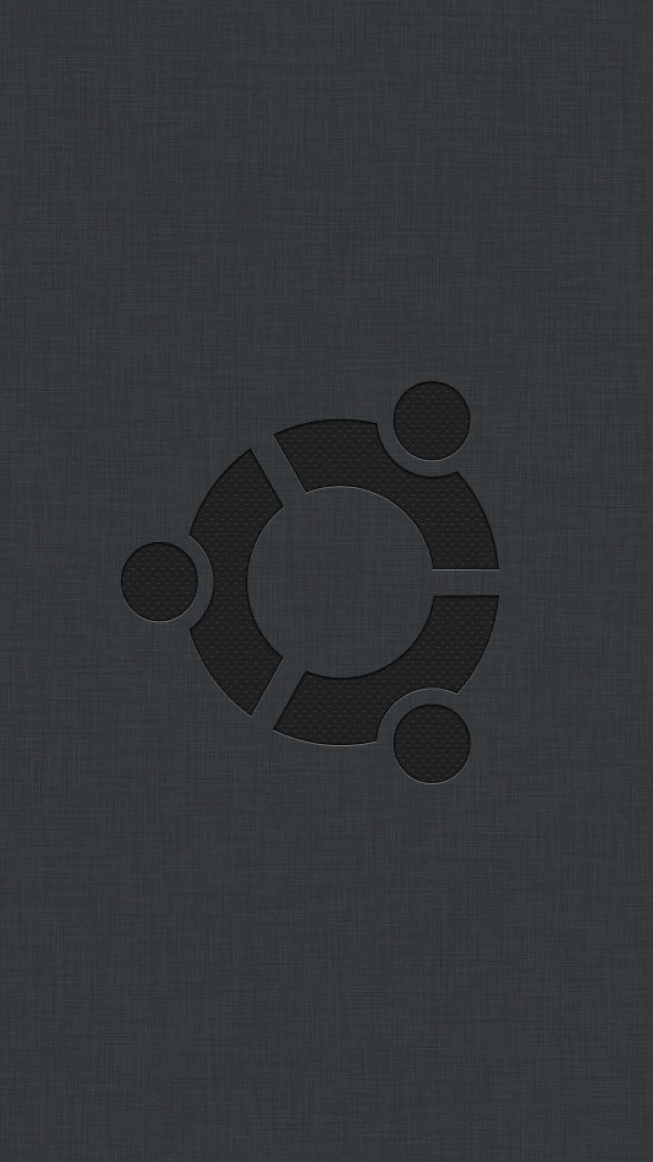 ubuntu 桌布 壁紙 — Ubuntu 標誌微妙地壓印在深色紋理布料背景上，呈現極簡單色美學。