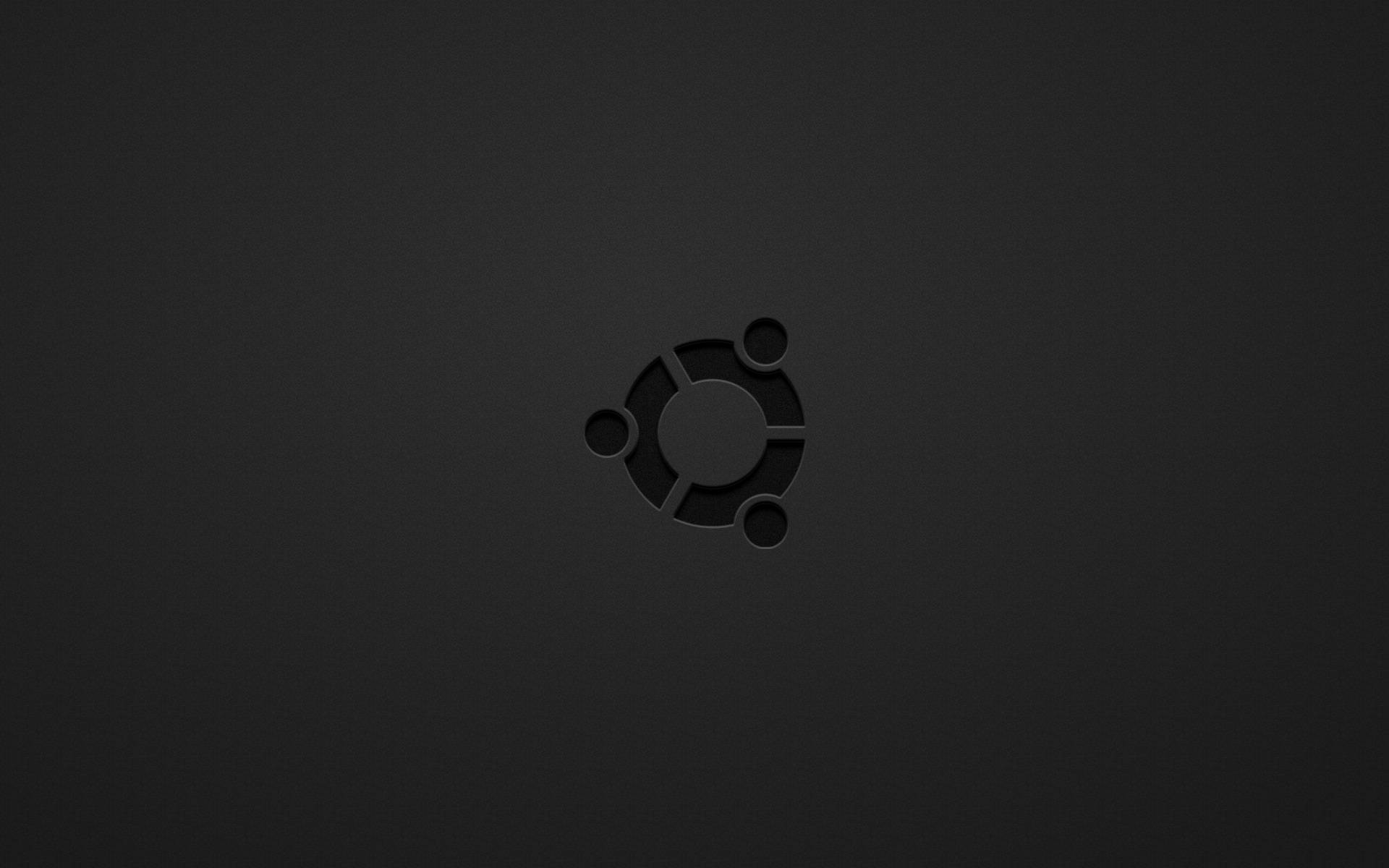 ubuntu 桌布 壁紙 — Ubuntu 標誌微妙地壓印在霧面黑色表面上，柔和光線突顯其圓形設計。