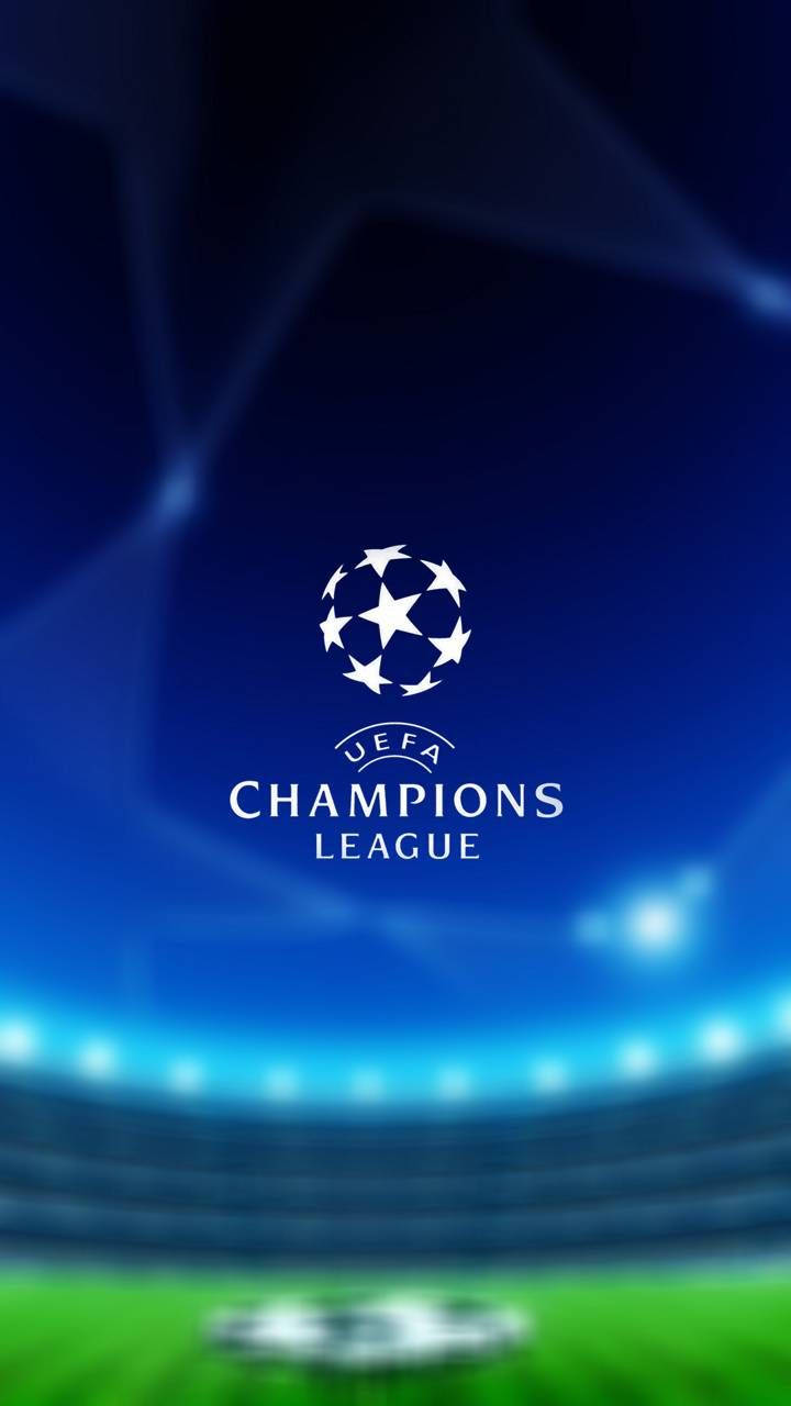 Uefa 桌布 壁紙 — UEFA Champions League 標誌居中於模糊的體育場，帶有發光的藍色燈光和綠色球場。