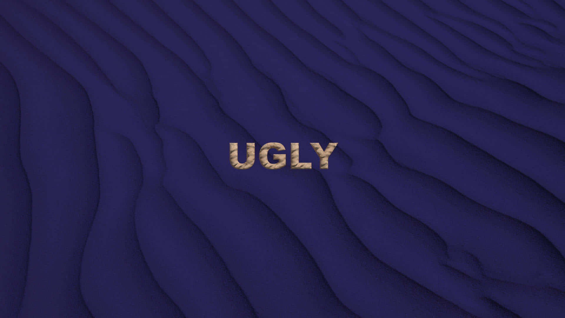 ugly 桌布 壁紙 — 「ugly」一詞以帶紋理的金色字母呈現，置於帶柔和陰影的深藍色波浪表面上。