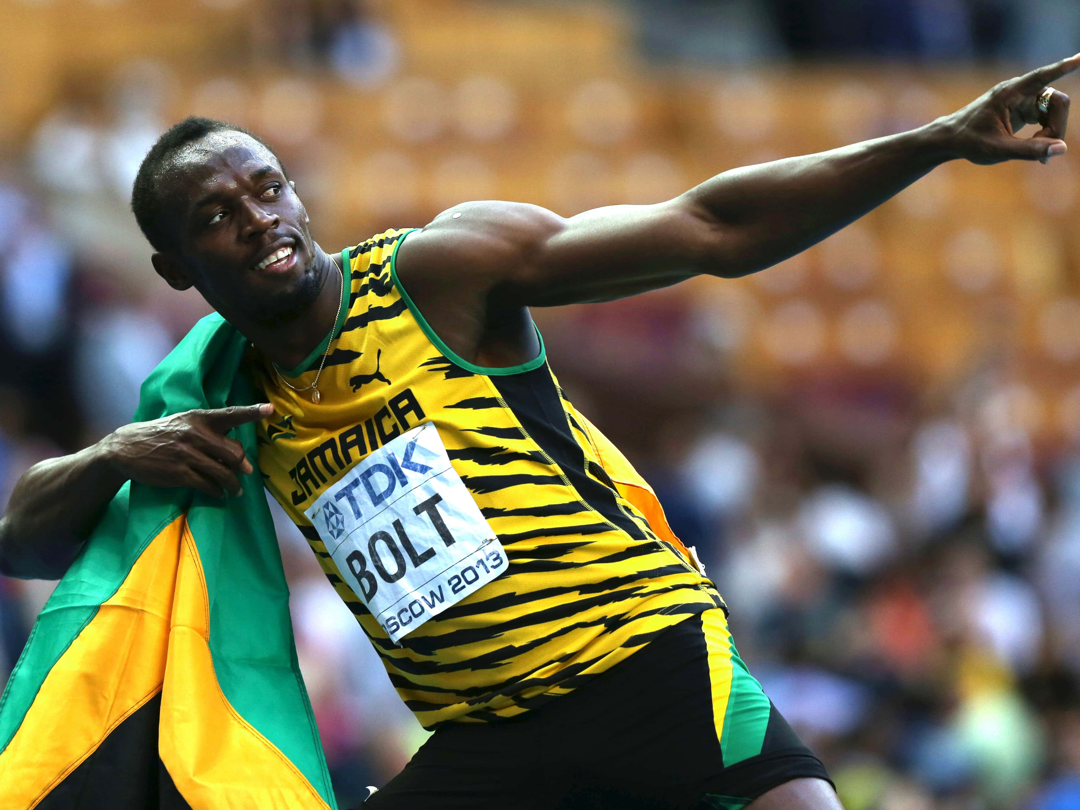 運動 桌布 壁紙 — Usain Bolt 在2013年世界錦標賽中穿著黃黑條紋球衣，披著牙買加國旗慶祝勝利。
