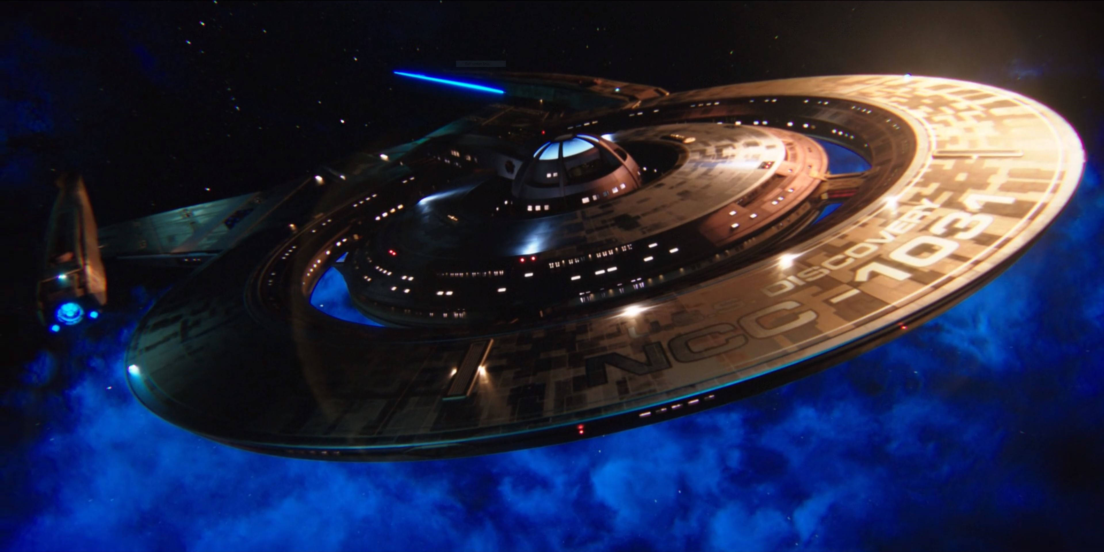 Discovery 桌布 壁紙 — USS Enterprise NCC-1701 在充滿活力的藍色星雲中滑行，星星在宇宙虛空中閃爍。