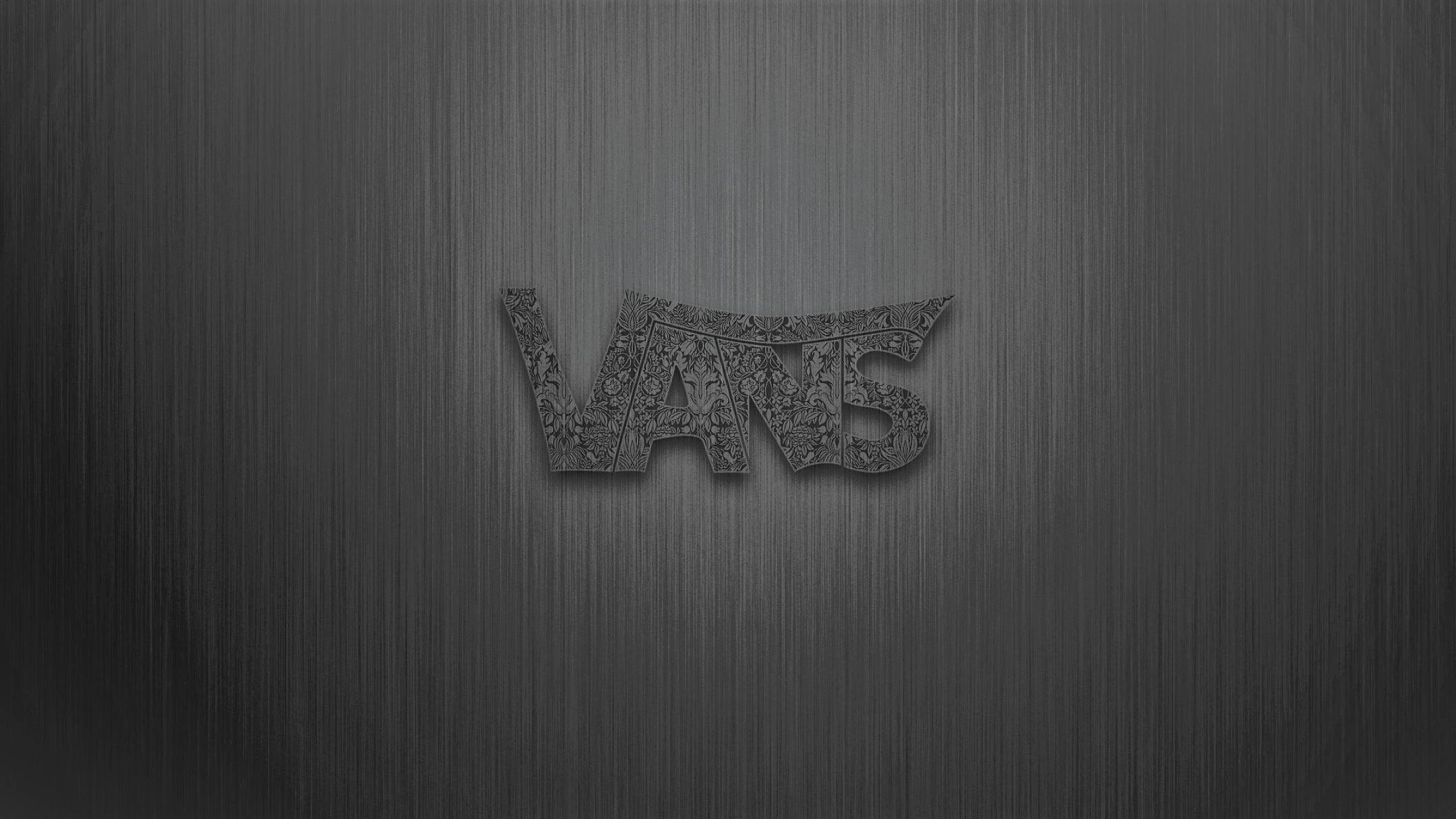 Vans Logo 桌布 壁紙 — VANS 標誌壓印在拉絲金屬表面上，字母內有精緻的花卉圖案。