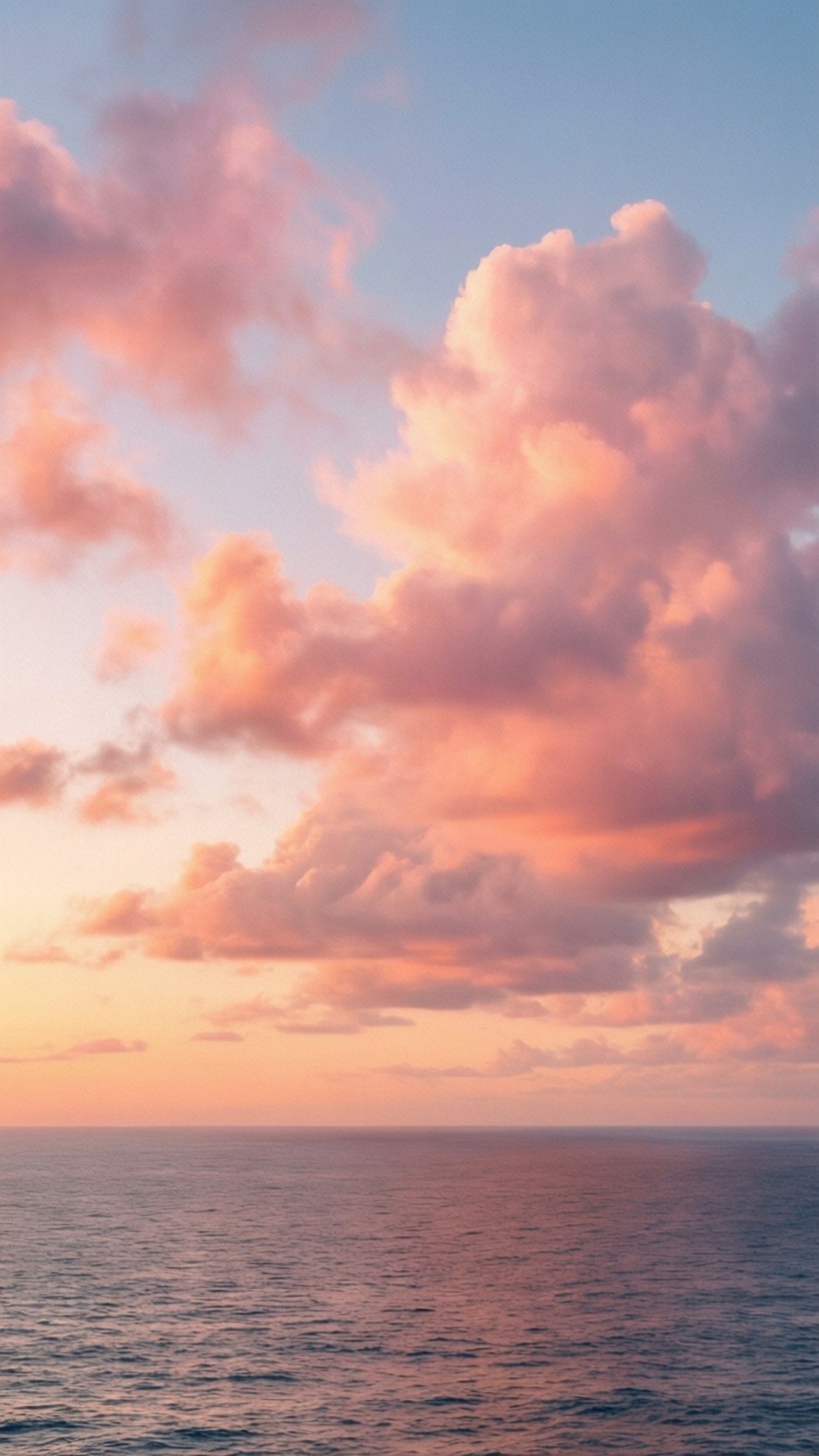 Pastel Sunset Clouds 壁紙 — 廣闊的海洋與天空相遇，天空被塗上柔和的粉紅、橙色和藍色調，雲朵在日落時發光。