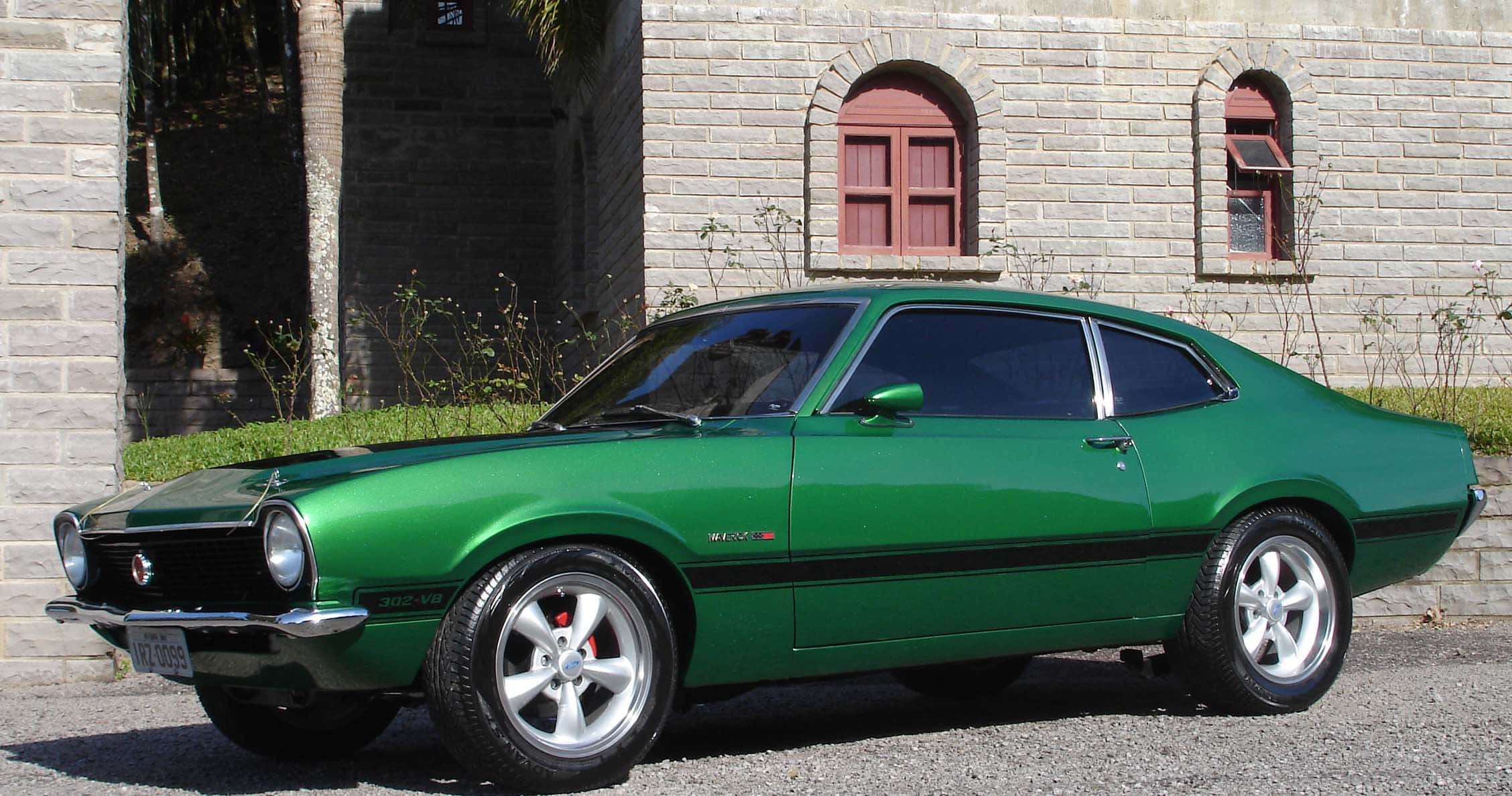 Ford Maverick 桌布 壁紙 — 一輛充滿活力的綠色經典肌肉車停在碎石路上，前方是帶有拱形窗戶的石頭建築。