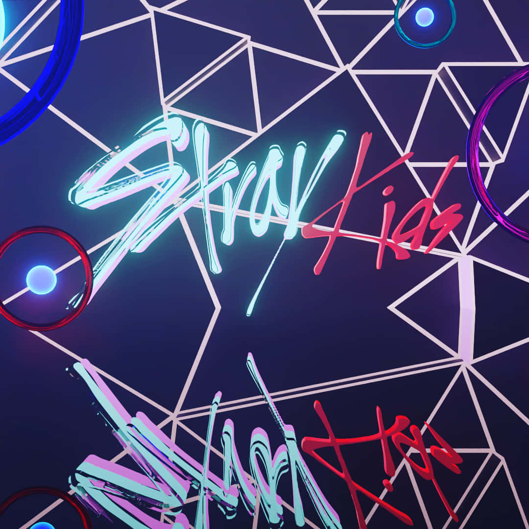  壁紙 — 充滿活力的霓虹塗鴉文字「Stray Kids」在帶有彩色圓形點綴的深色幾何網格上發光。
