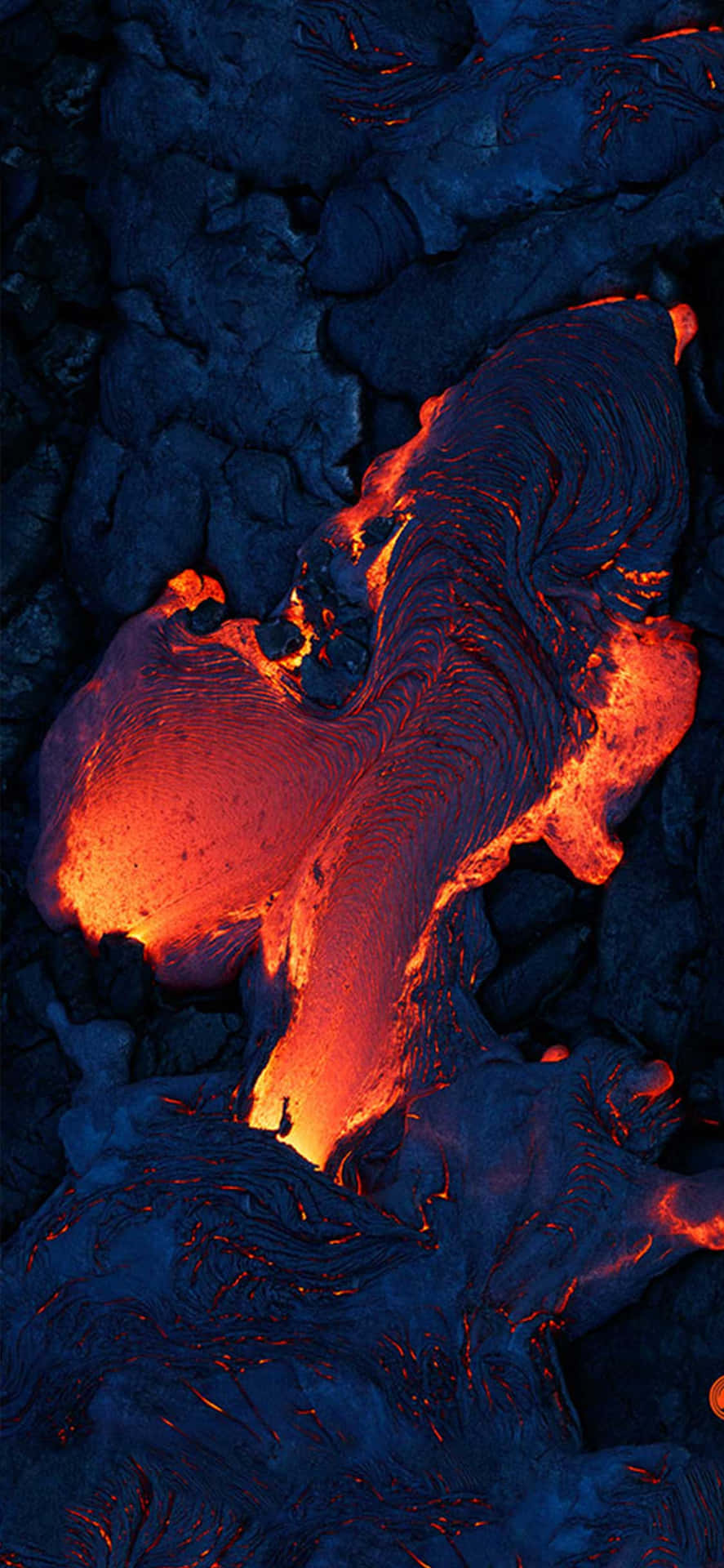 熔岩在深色火山岩中發出橙色光芒。 — Oled 壁紙