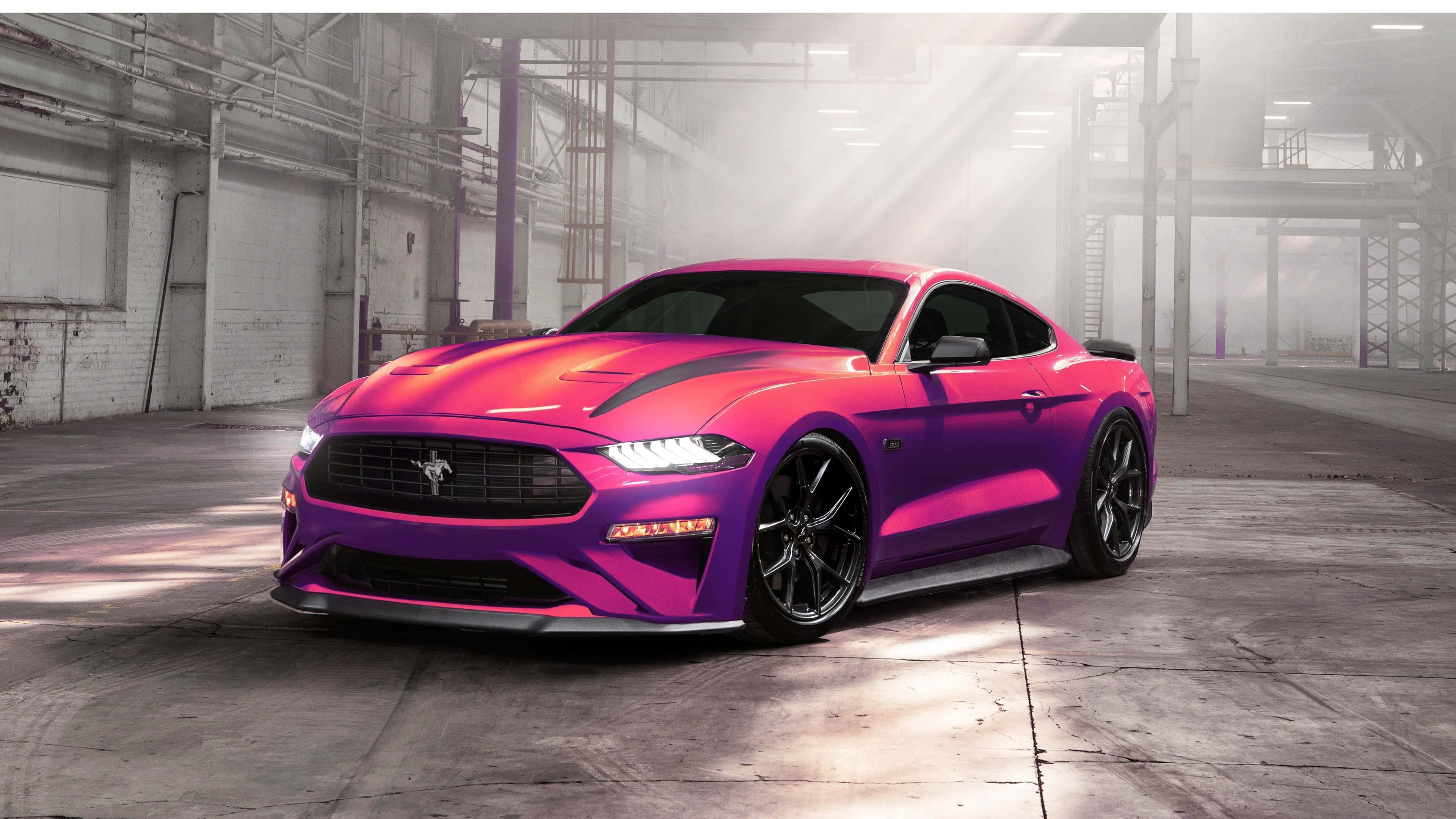 Ford Mustang Ecoboost 桌布 壁紙 — 一輛充滿活力的漸變紫色和粉紅色福特野馬跑車在霧氣瀰漫的工業倉庫中，在戲劇性的陽光光束下閃閃發光。