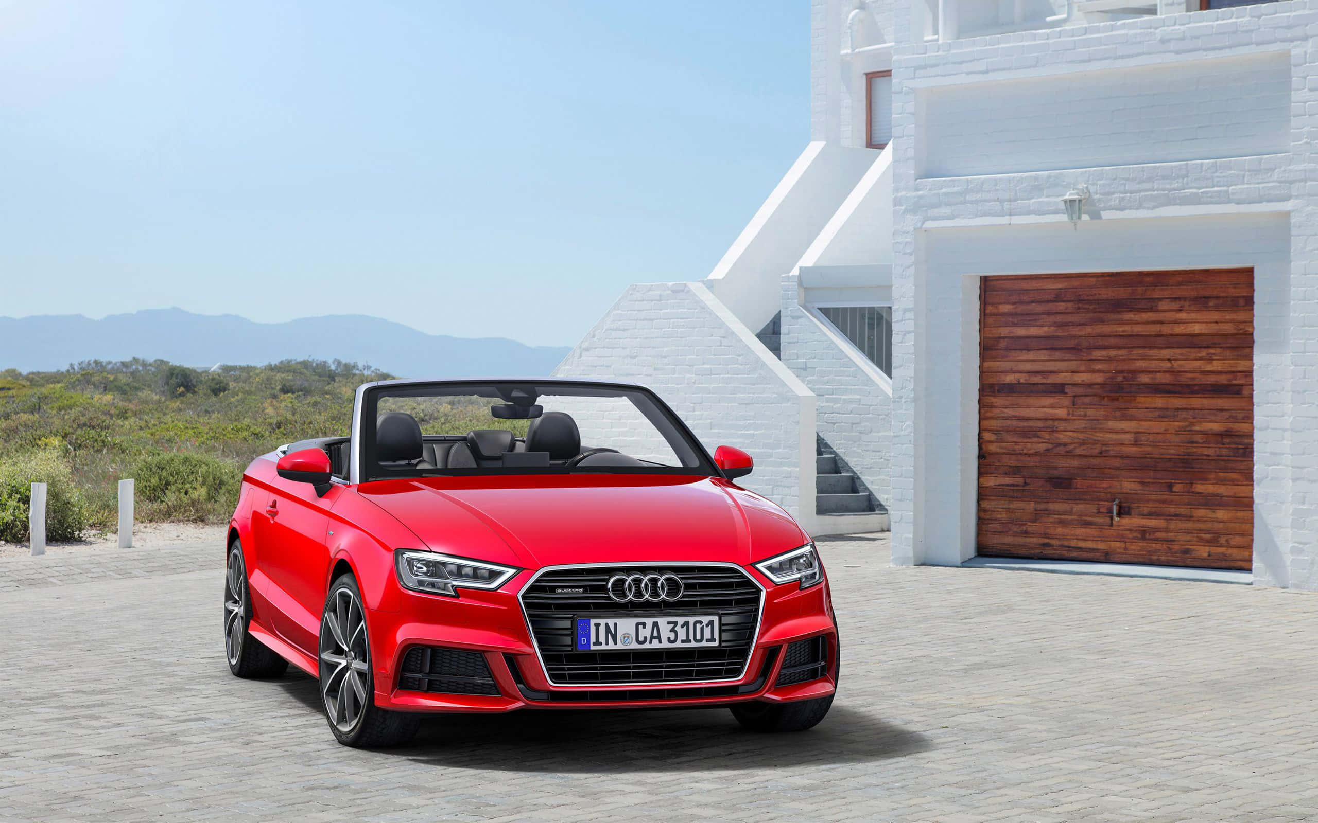 Audi A3 桌布 壁紙 — 一輛鮮紅色的奧迪敞篷車停在一棟現代白色房屋前，房屋有木製車庫門，天空清澈湛藍。