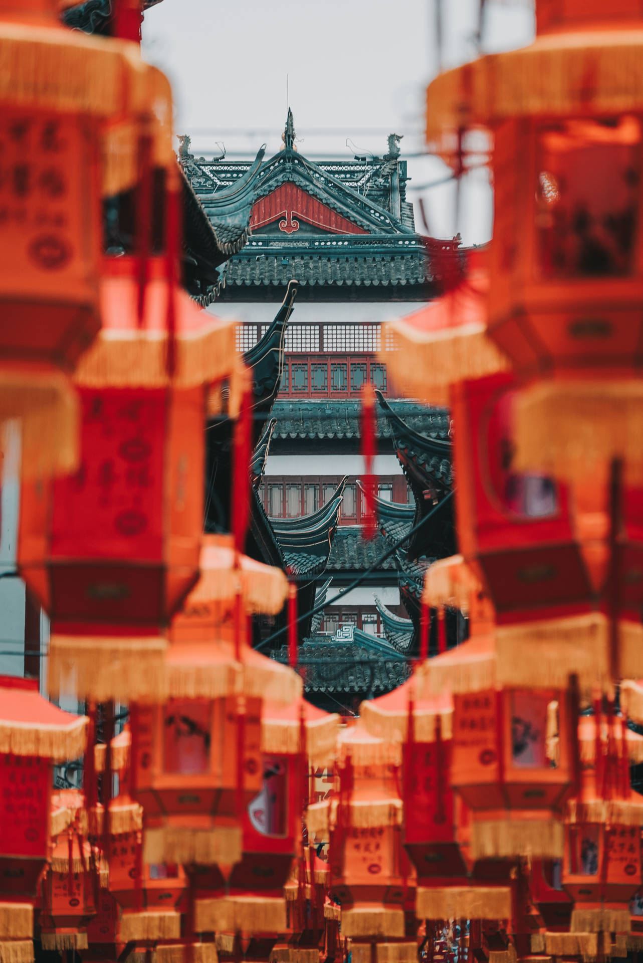 紅色燈籠掛在傳統中國寶塔前，寶塔有瓦片屋頂。 — 春節 壁紙