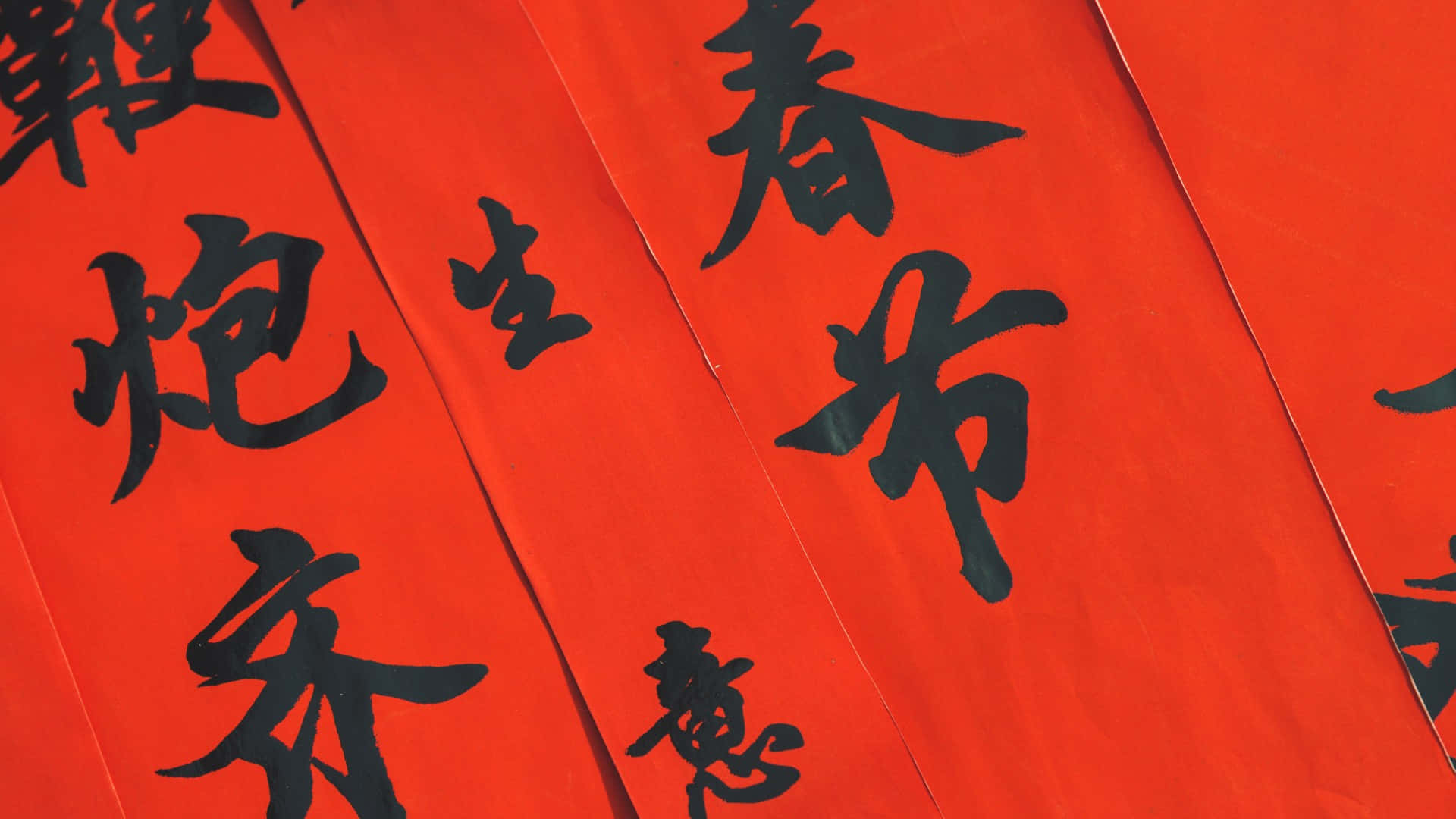  壁紙 — 鮮紅色紙張飾以粗體黑色中國書法字體，用於農曆新年慶祝活動。