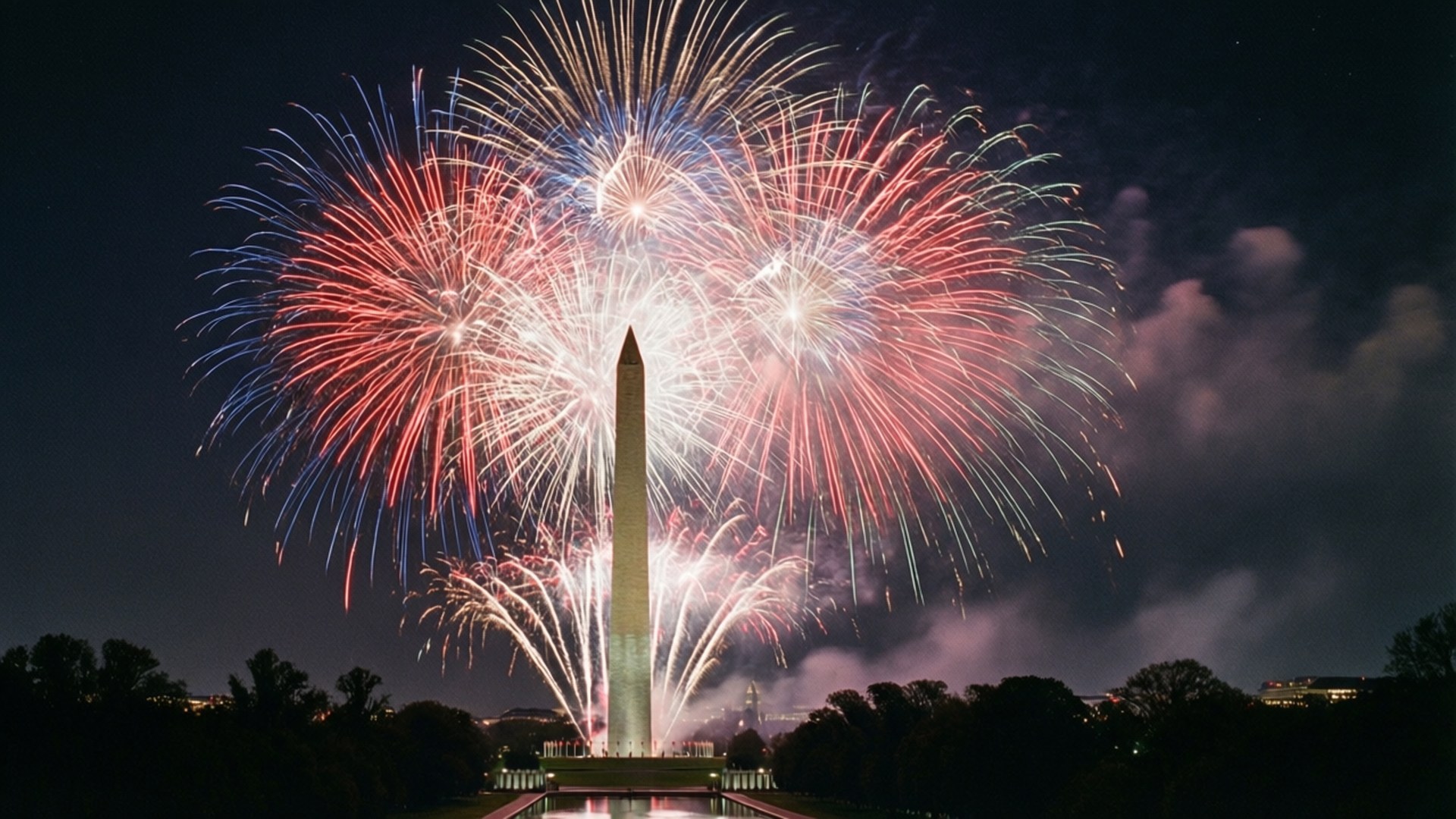Monumental Fireworks 壁紙 — 鮮豔的紅、白、藍煙火在夜間於華盛頓紀念碑上空爆炸，以耀眼的光芒照亮天空。
