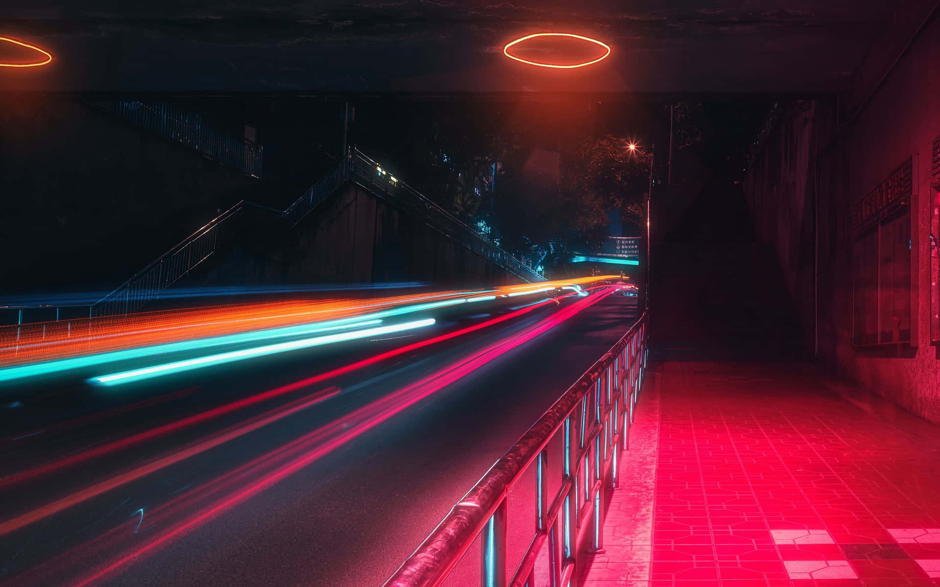  壁紙 — 鮮豔的霓虹光條在夜晚穿過黑暗的城市隧道，在瓷磚路面上投射出發光的紅色倒影。