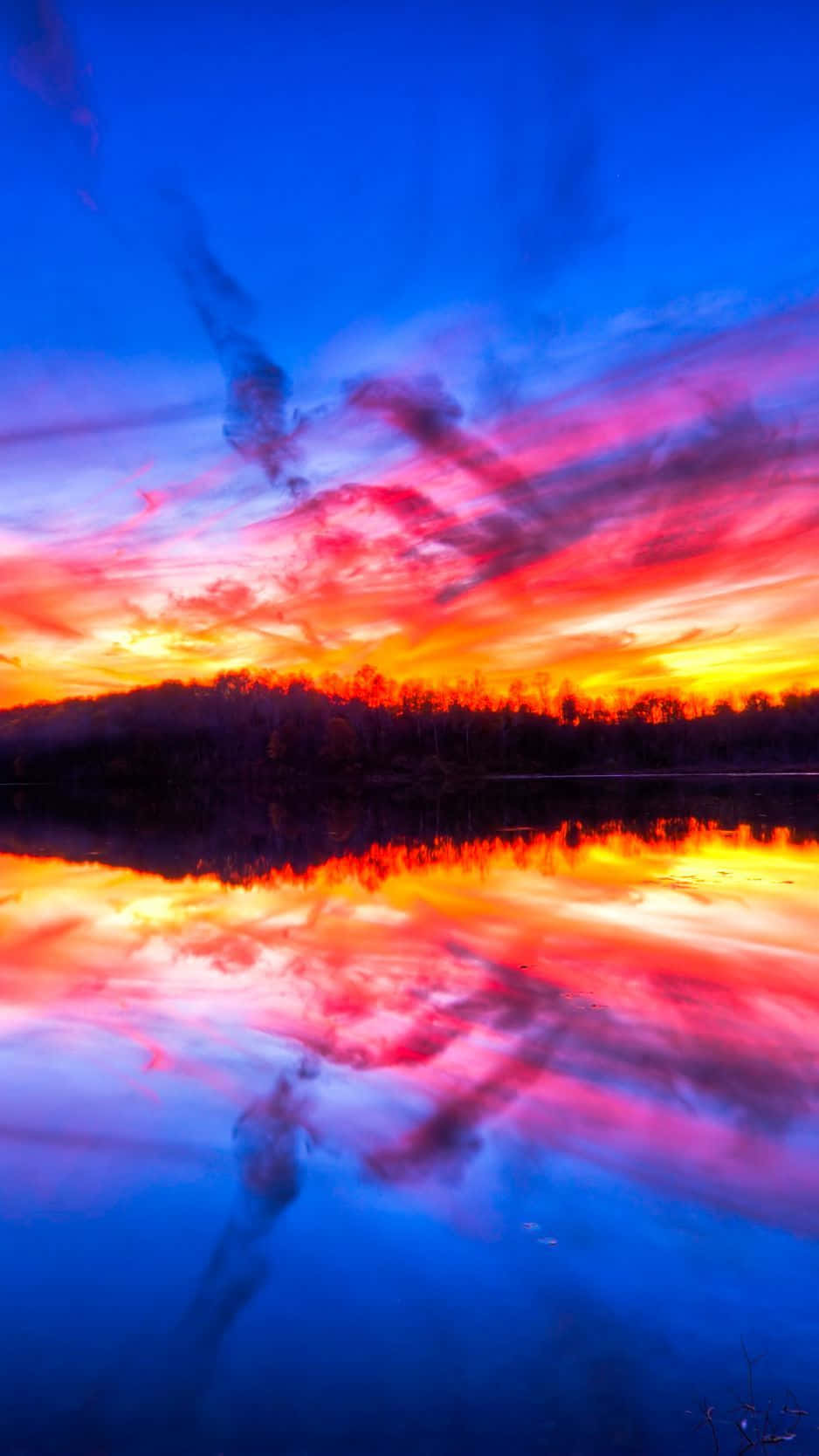 Colorful Sunset 桌布 壁紙 — 充滿活力的日落將天空染成火熱的橙色和粉紅色，完美地倒映在下方平靜的湖面上。