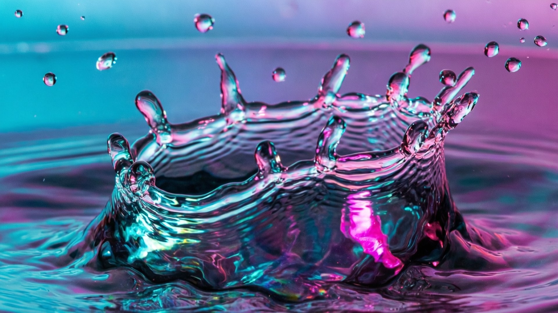 Splash of Hologram 壁紙 — 一個充滿活力的水滴皇冠向上濺起，背景是青綠色和洋紅色的漸變。