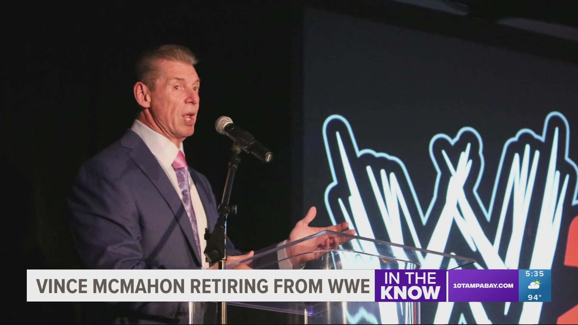 Retirement 桌布 壁紙 — Vince McMahon 在舞台燈光下進行退休公告時，在身後有WWE標誌的講台上發言。