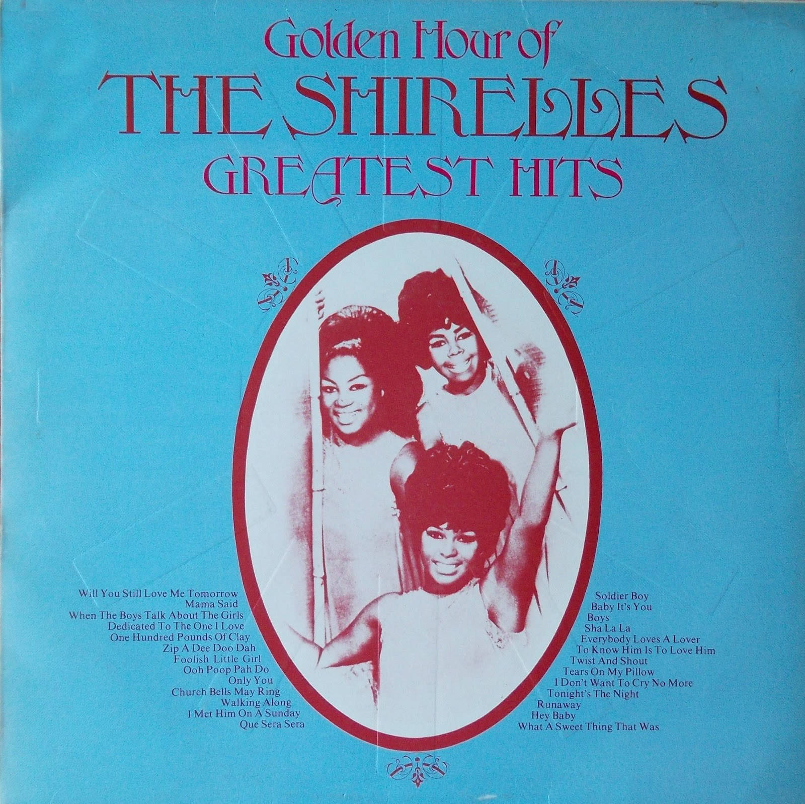 Album Cover 桌布 壁紙 — The Shirelles' Greatest Hits 的復古專輯封面，藍色背景上有一個紅色橢圓形，內有三個微笑的女性。
