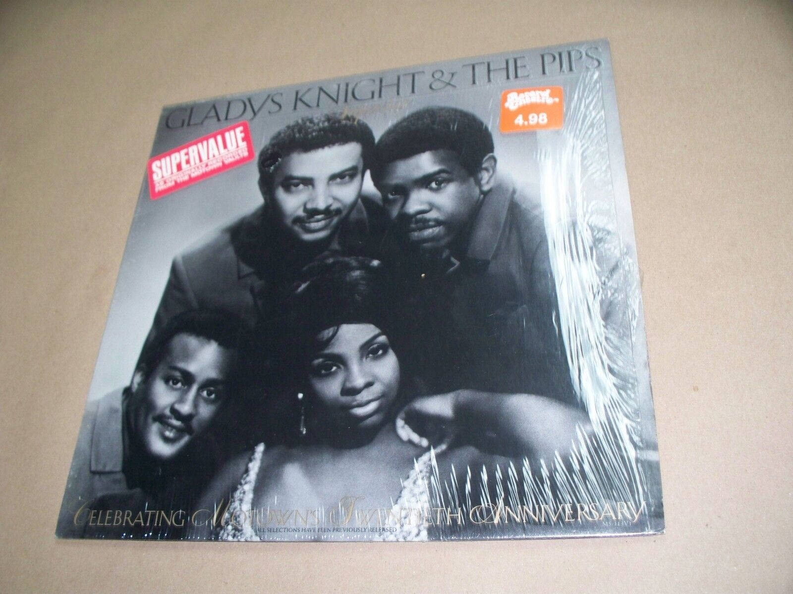 album 桌布 壁紙 — Gladys Knight & The Pips 的復古黑白黑膠唱片封套，密封在塑膠中，放在米色表面上。