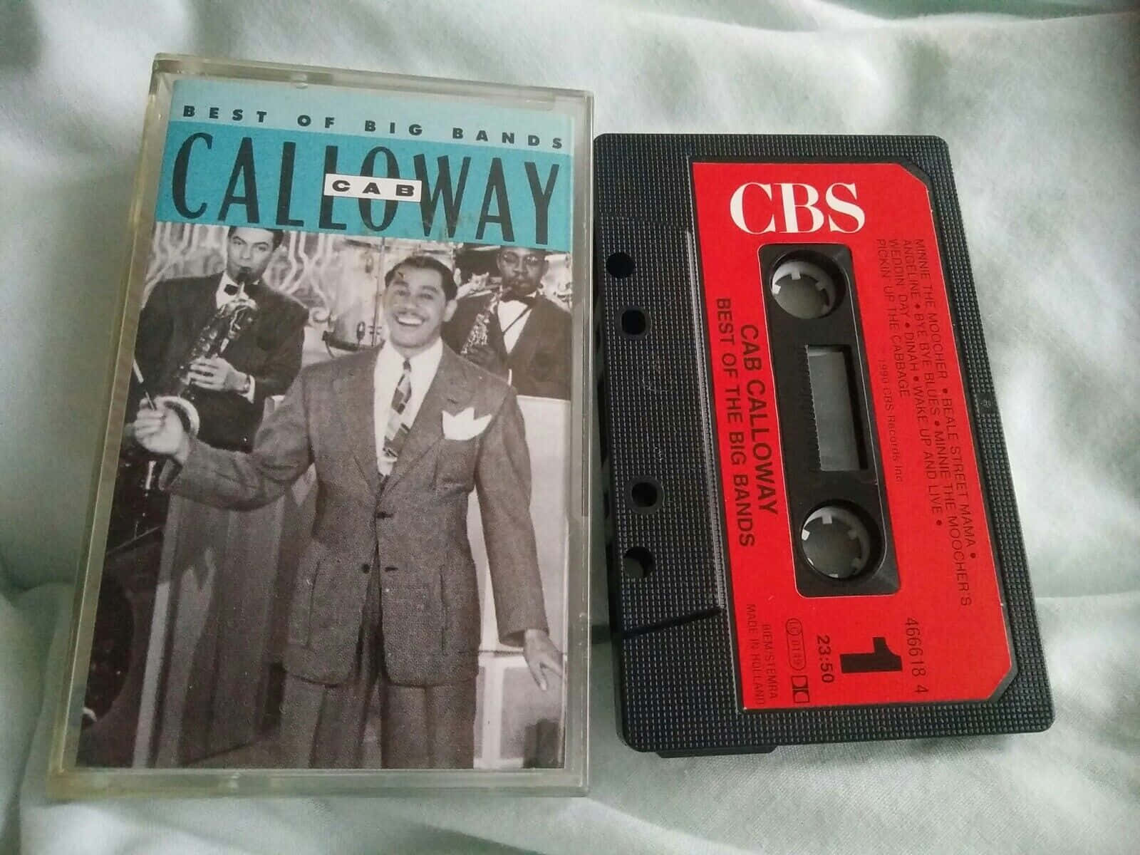  壁紙 — Cab Calloway 的 'Best of Big Bands' 復古卡式錄音帶及盒套放在柔軟的白色布料背景上。