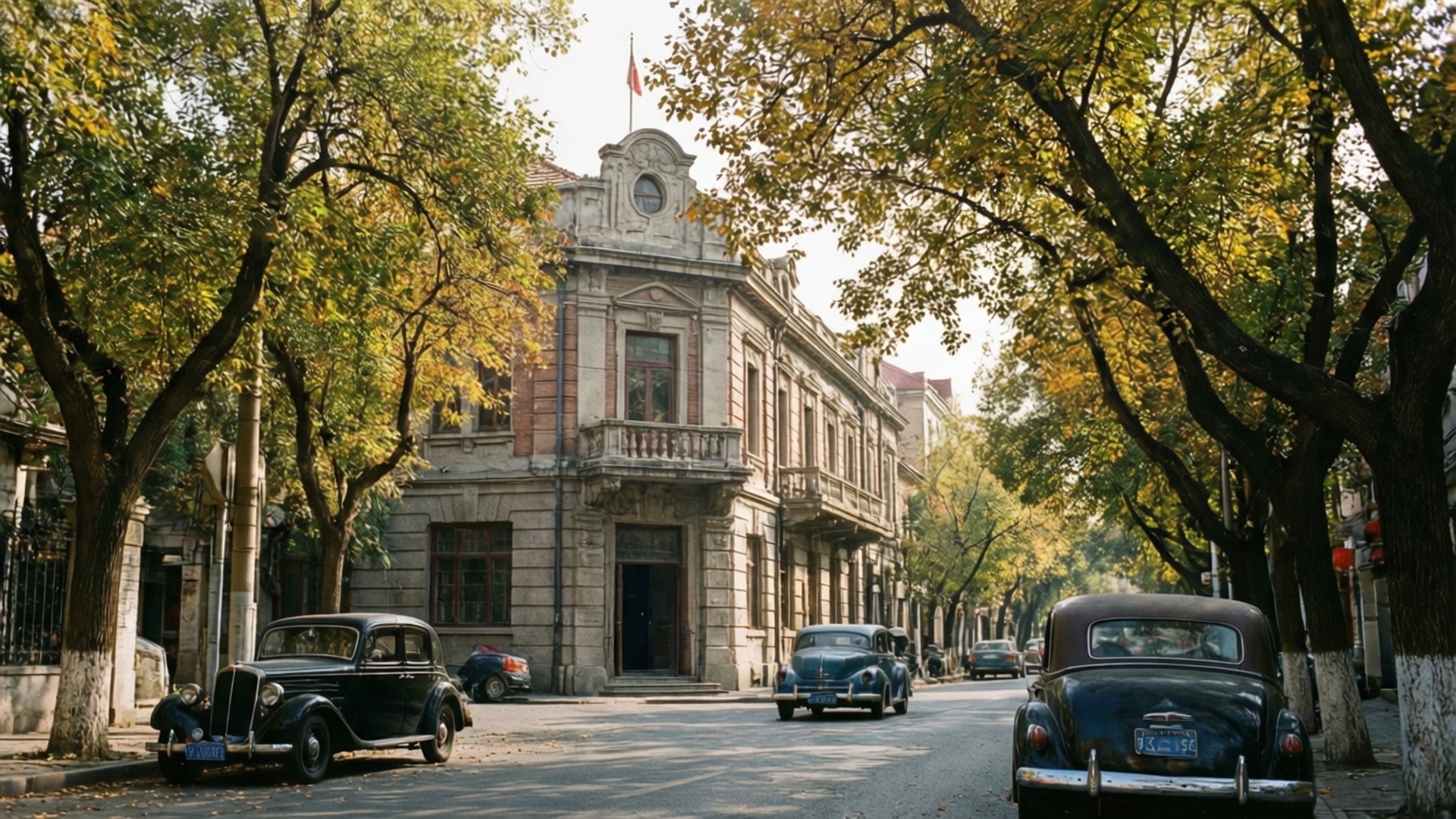 Five Great Avenue Autumn 壁紙 — 復古汽車排列在樹蔭大道旁，旁邊是一座宏偉的石建築，沐浴在金色的秋光中。