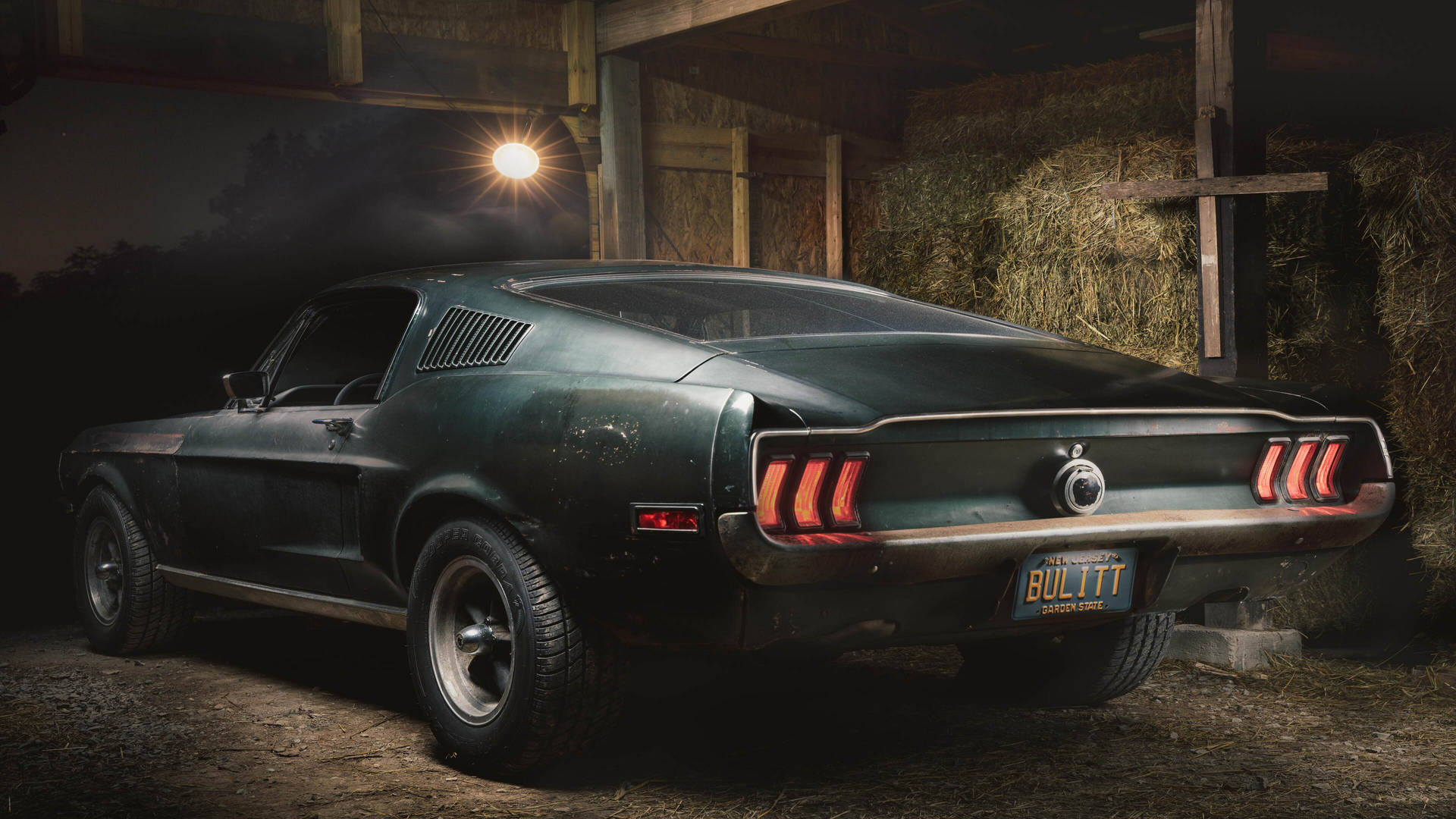 夜間停放在充滿乾草的穀倉中的復古綠色Mustang Bullitt。 — 4K 超高清 壁紙