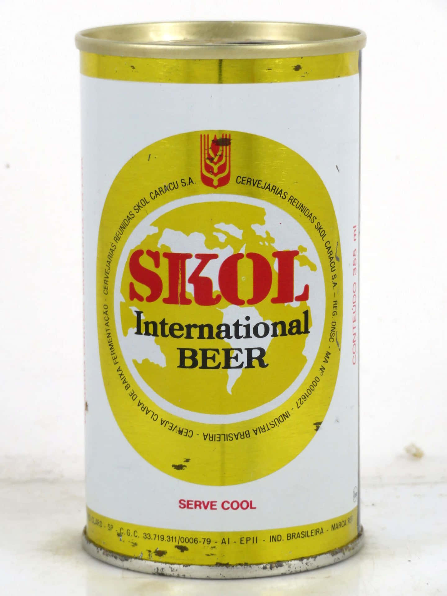  壁紙 — 一個復古的SKOL International Beer罐，帶有黃色和白色的標籤，顯示世界地圖和紅色文字，背景為素色。