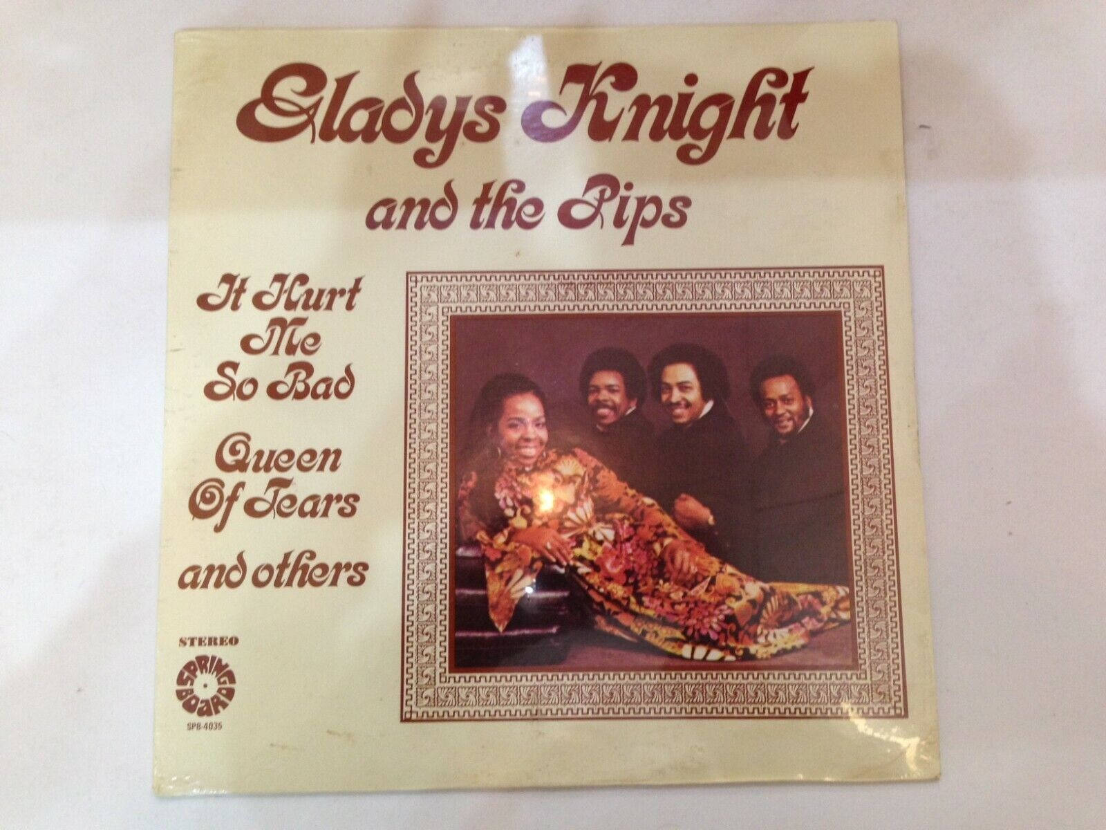 album 桌布 壁紙 — Gladys Knight and the Pips 的復古黑膠唱片專輯封面，以溫暖燈光的肖像、華麗邊框和粗體紅色字體呈現。