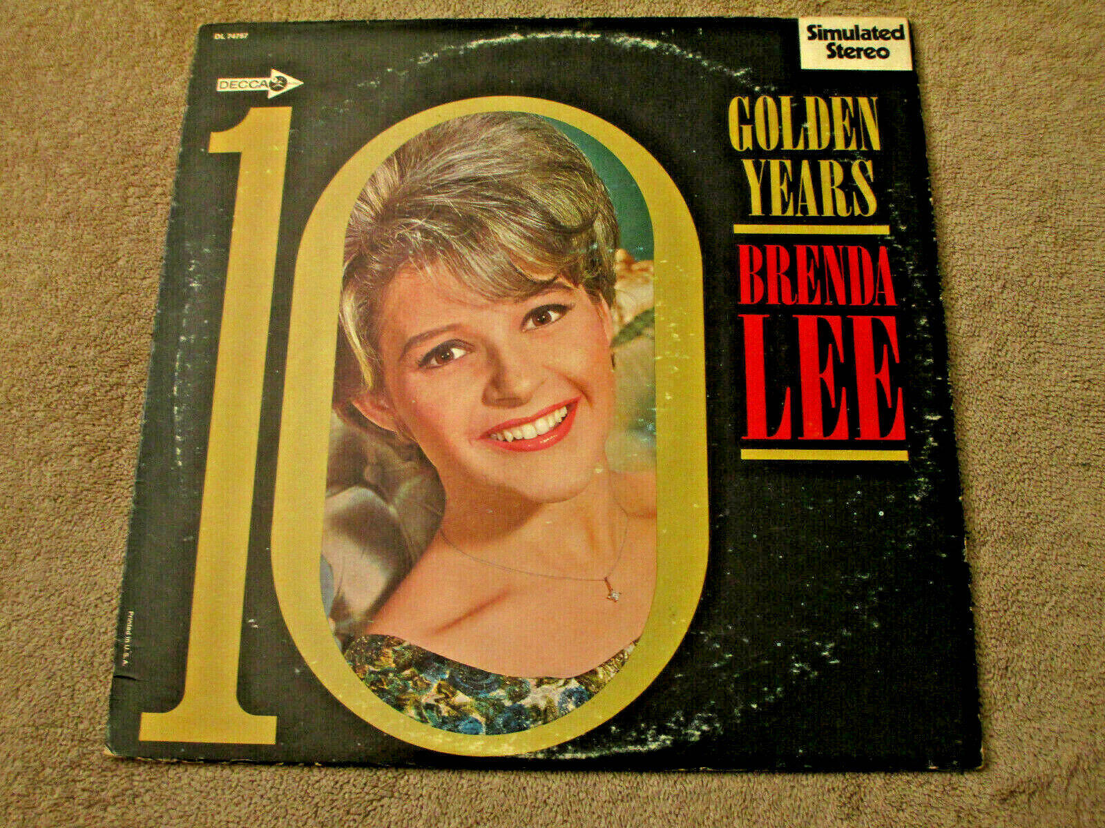 復古 桌布 壁紙 — Brenda Lee《10 Golden Years》的復古黑膠唱片封面，黑色背景上金色數字十內有一個微笑的肖像。