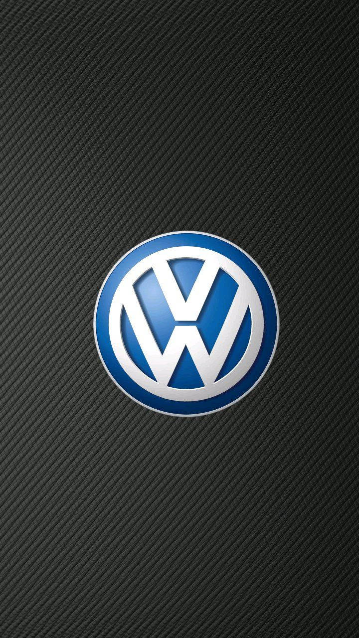 福斯汽車 桌布 壁紙 — Volkswagen 標誌在帶有紋理的黑色碳纖維背景上閃耀著金屬藍色和銀色。