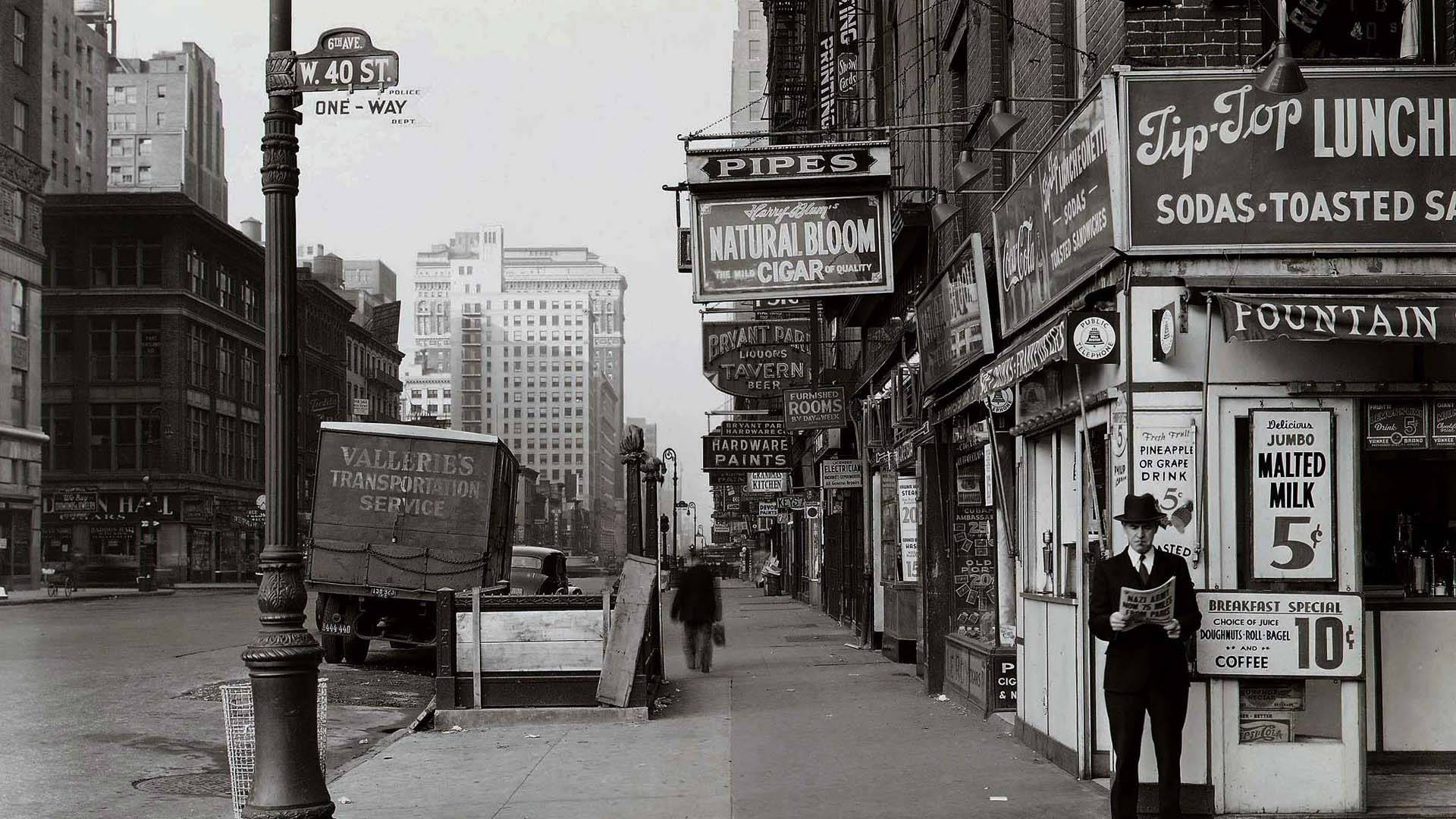 hollywood street 桌布 壁紙 — W 40 St 的復古黑白街景，一名男子在商店櫥窗附近閱讀報紙，路邊停著一輛卡車。