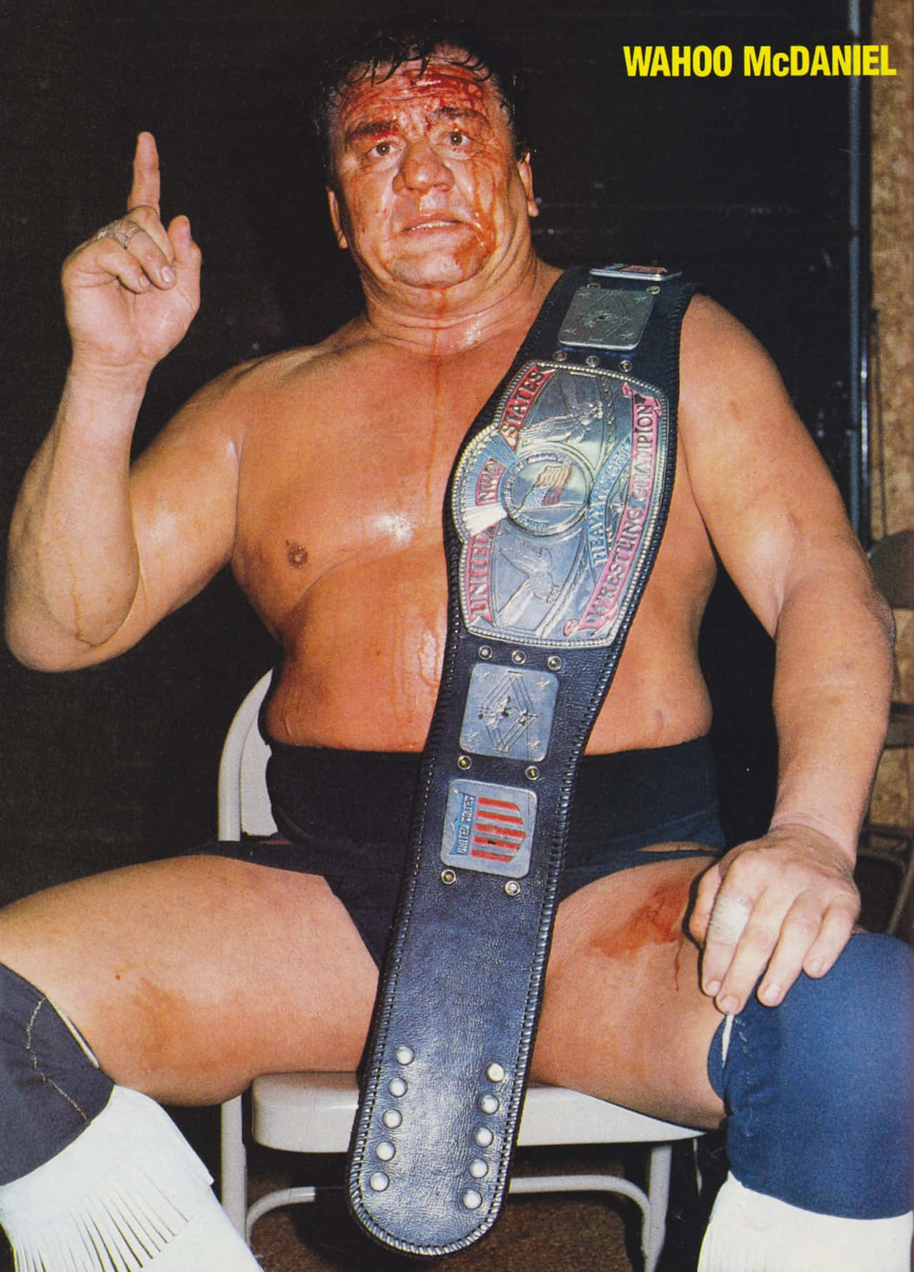WWE 桌布 壁紙 — Wahoo McDaniel 坐在椅子上，戴著冠軍腰帶，臉上和身上有血。