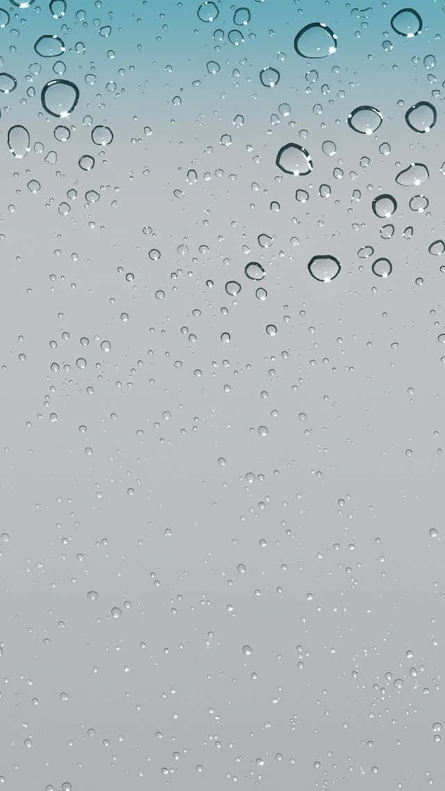  壁紙 — 雨滴依附在玻璃表面上，背後是從青綠色到灰色的漸變天空。