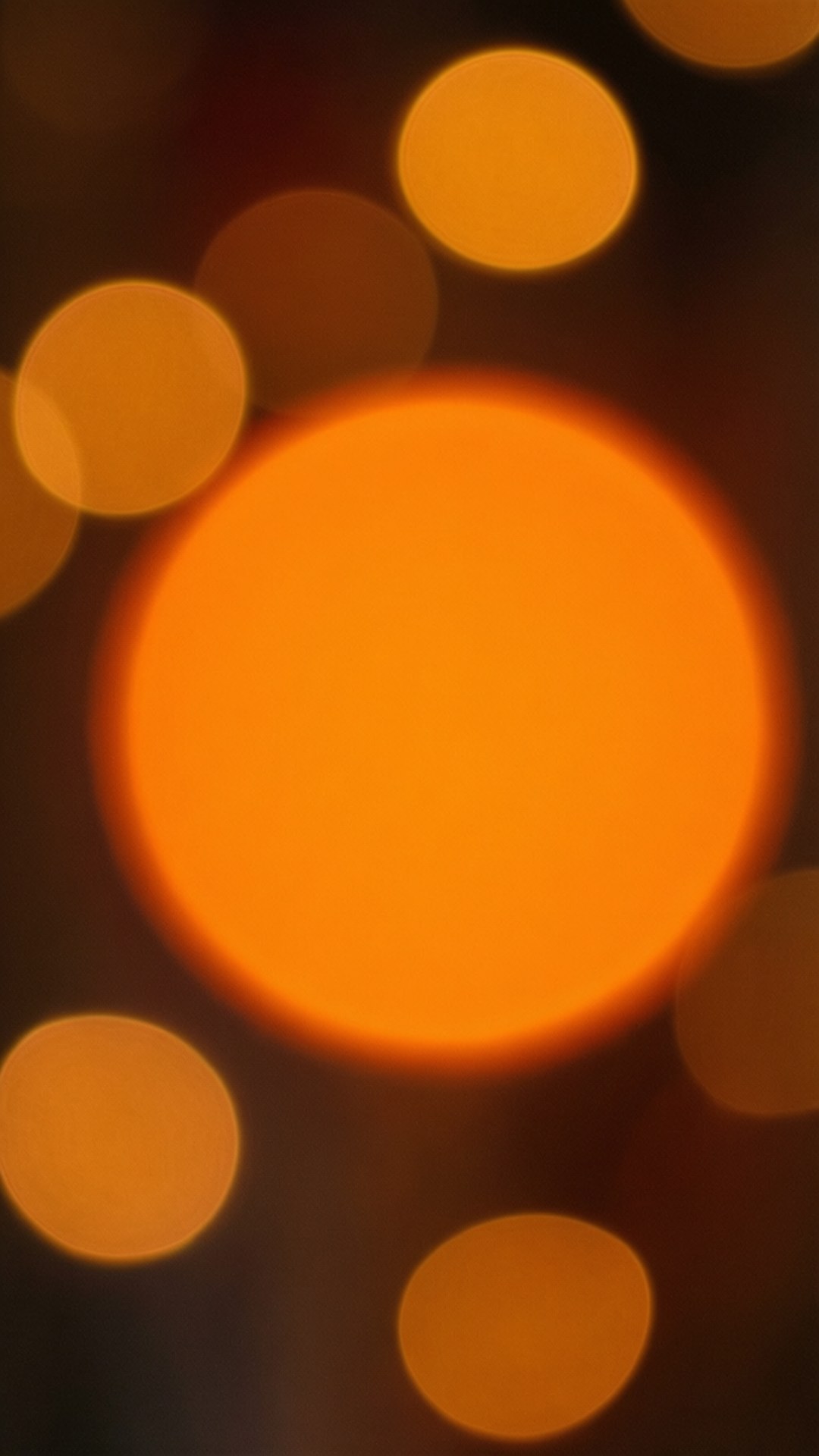 Bokeh Orange Depth 壁紙 — 溫暖抽象構圖，發光的橙色散景圓圈在黑暗背景上柔和模糊。