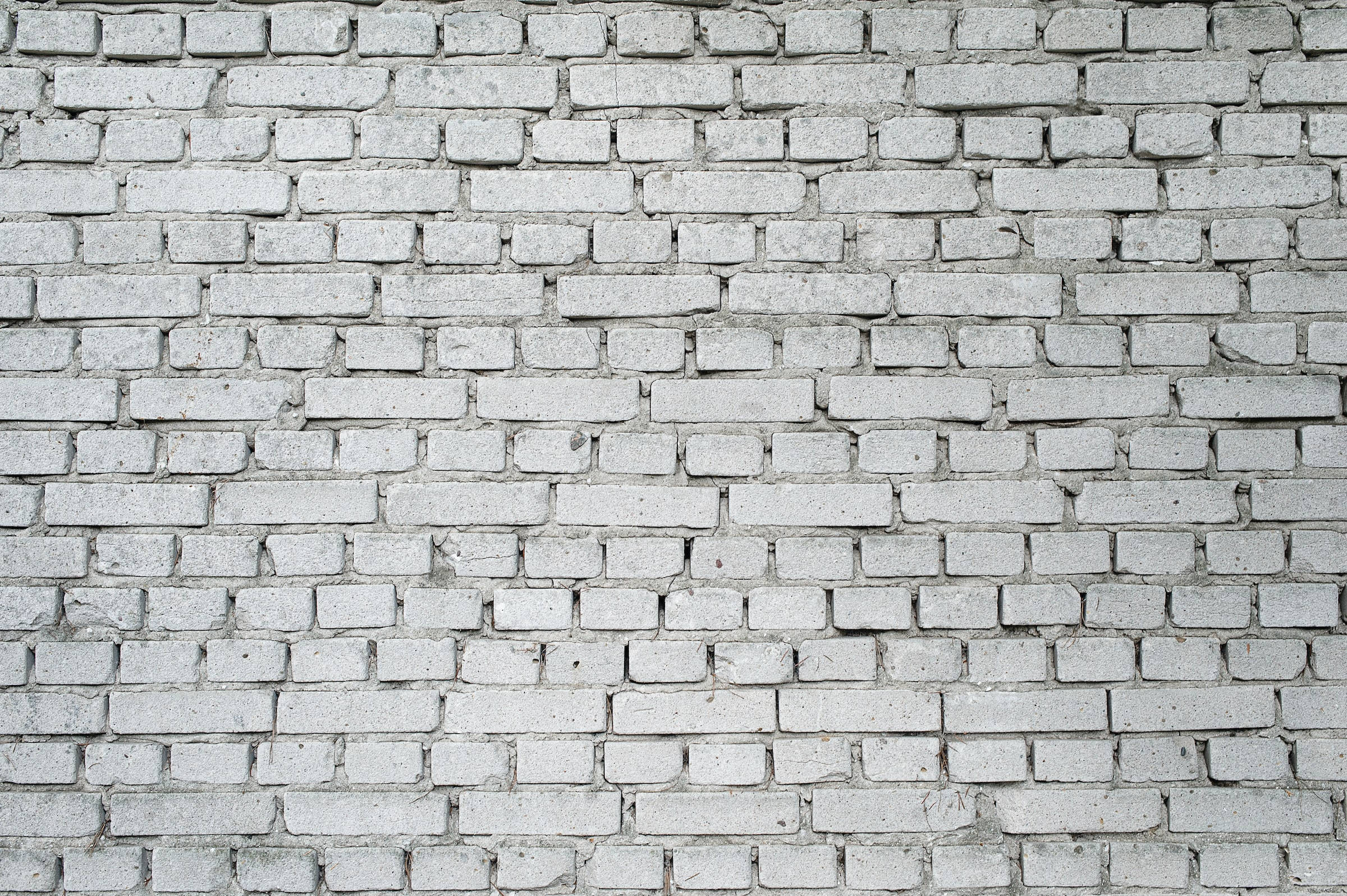Brick 桌布 壁紙 —  weathered 白色磚牆的特寫，可見砂漿線條和細微的紋理變化。