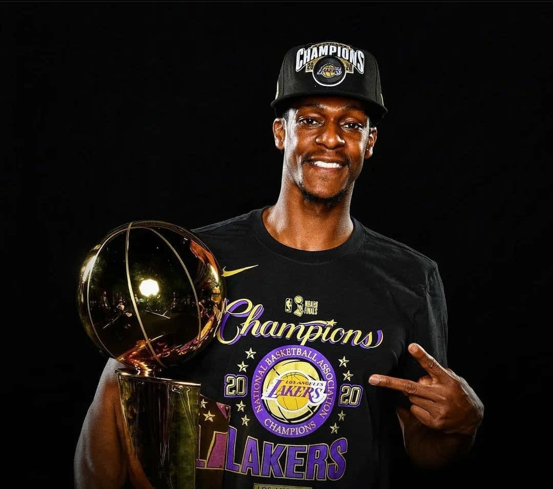  壁紙 — 一位微笑的籃球運動員，身穿黑色「Champions」T恤和帽子，在深色背景前手持閃亮的NBA獎盃。