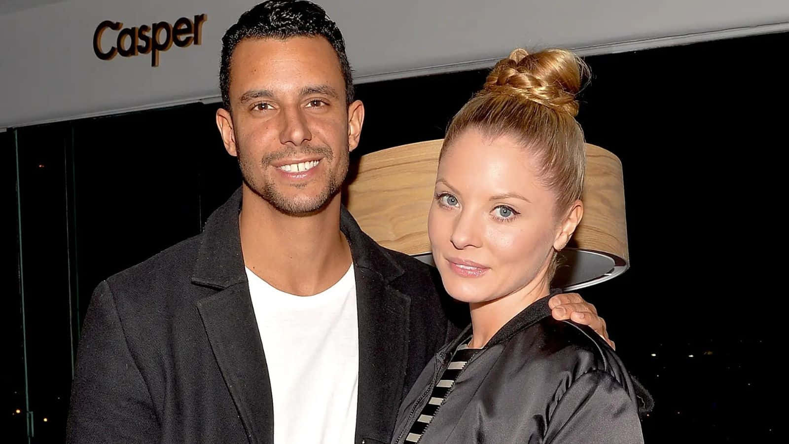 Kaitlin Doubleday 桌布 壁紙 — 一位微笑的男士和女士在Casper活動中一起擺姿勢，身後有一盞大燈。