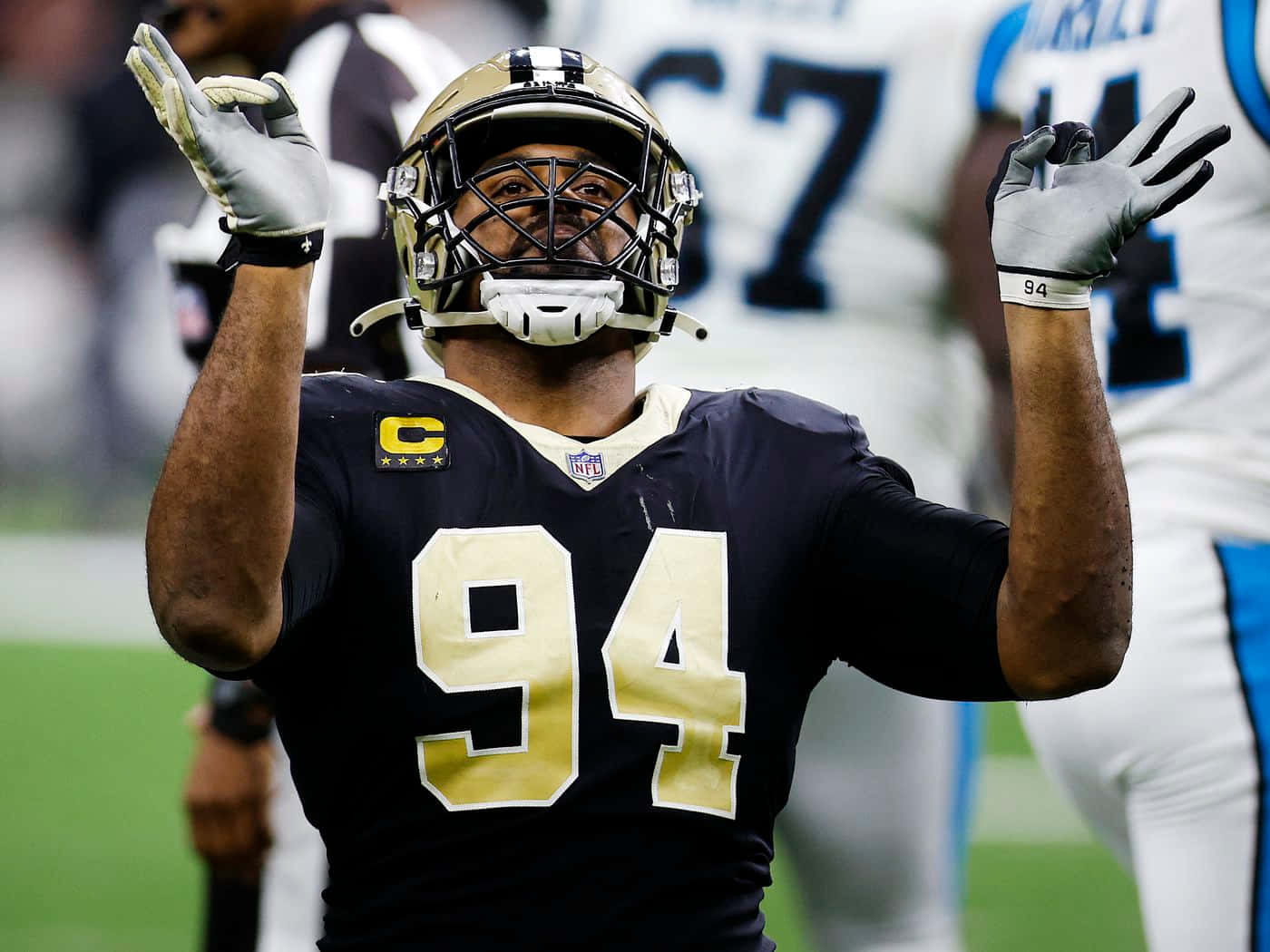 NFL 94號球員在足球場上舉手慶祝。 — Jordan 壁紙