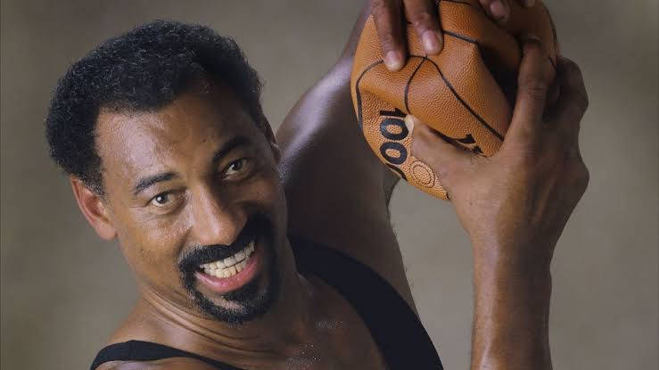 一位快樂的籃球運動員手持一個印有 '100' 的球。 — NBA 壁紙