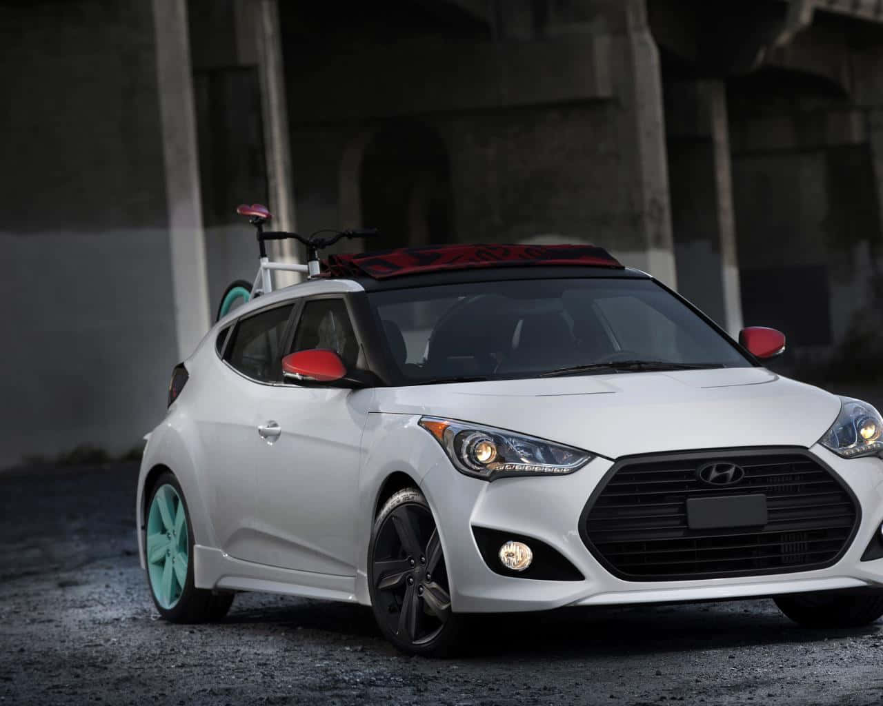 Hyundai Veloster 桌布 壁紙 — 一輛白色現代Veloster，配薄荷綠色車輪，車頂載著一輛紅色腳踏車，停泊在混凝土天橋下。