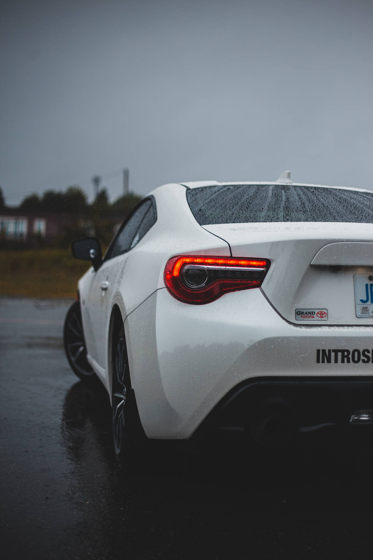 白色跑車在雨中濕路上亮起紅色尾燈。 — Toyota Supra 壁紙