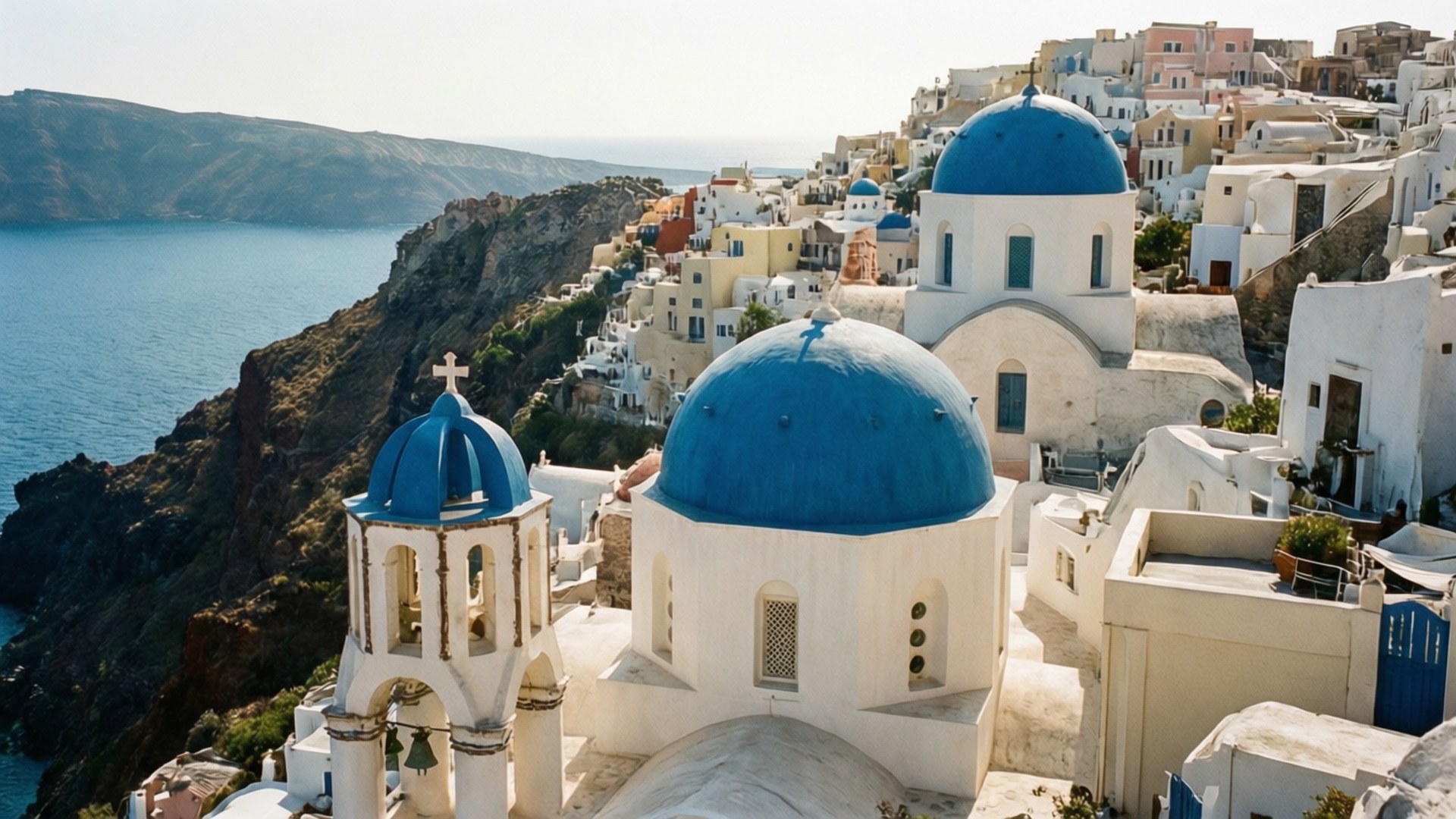 Oia Blue Domes Aerial 壁紙 — 白色建築物搭配標誌性藍色圓頂，依附在懸崖邊，俯瞰深藍色的愛琴海。