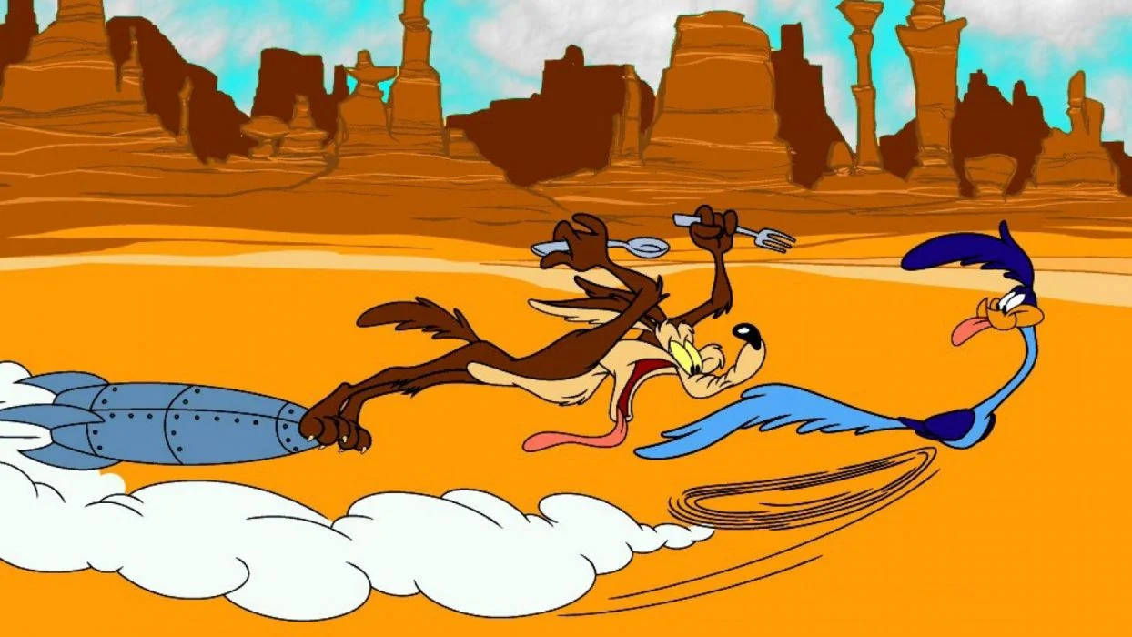 Coyote 桌布 壁紙 — Wile E. Coyote 背著火箭、手持叉子，在沙漠中追逐 Road Runner。