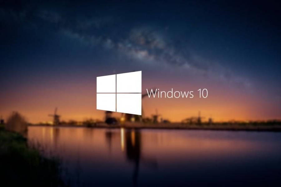 Windows 10 桌布 壁紙 — Windows 10 標誌漂浮在寧靜的暮色景觀上，風車倒映在星空下的平靜水面上。