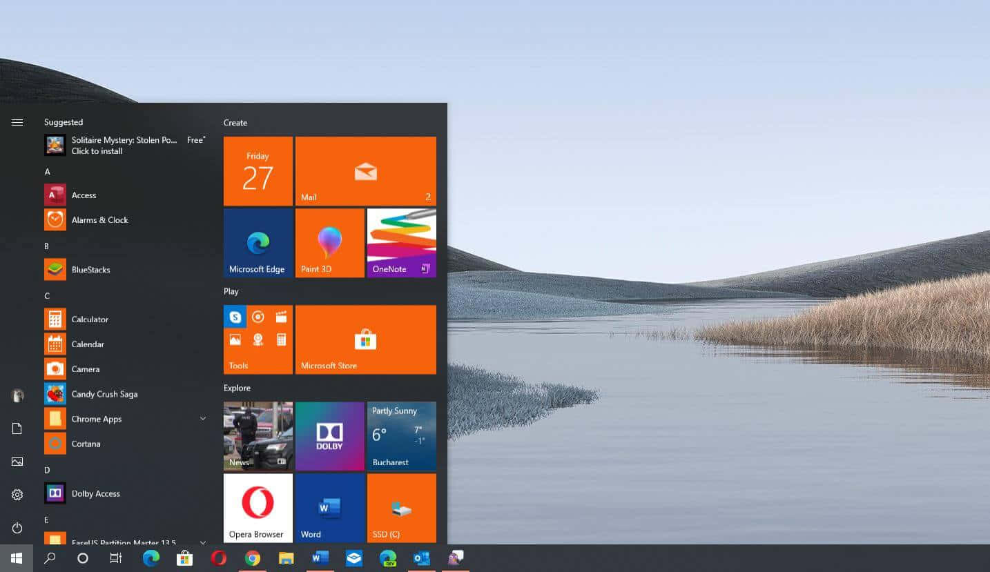Windows 桌布 壁紙 — Windows 10 開始功能表疊加在一個寧靜的湖面上，有蘆葦和起伏的山丘，天空晴朗。