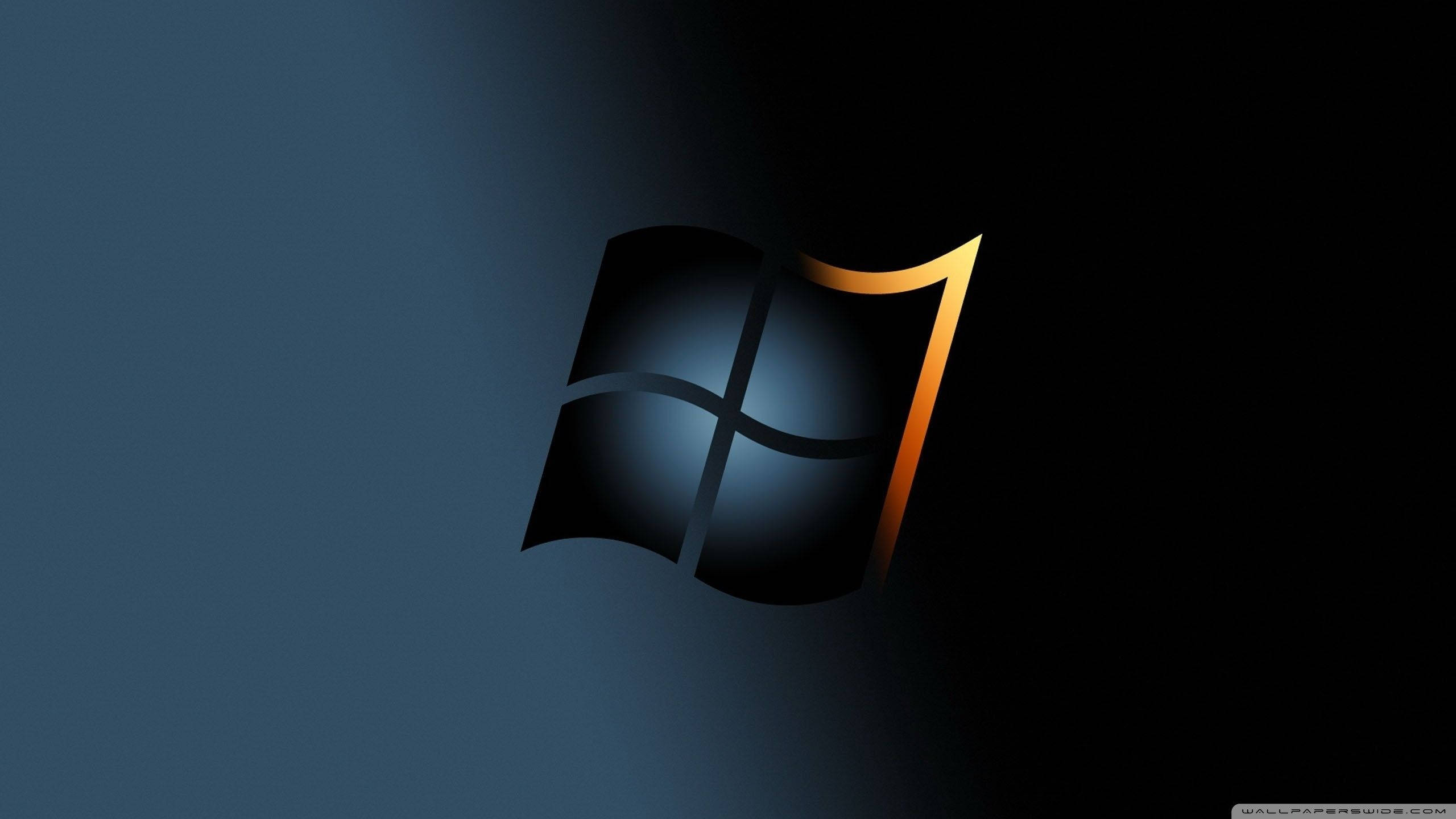 Windows 7 桌布 壁紙 — Windows 7 標誌在深藍色漸變背景上發出金色邊緣的光芒。