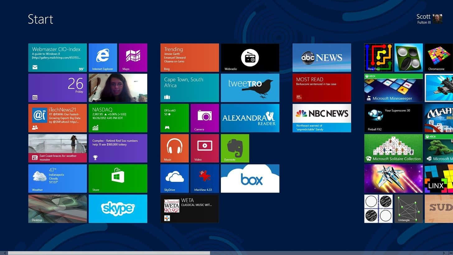 Windows Computer 桌布 壁紙 — Windows 8 開始畫面，深藍色背景上顯示彩色動態磚，展示應用程式、新聞、天氣和社交更新。