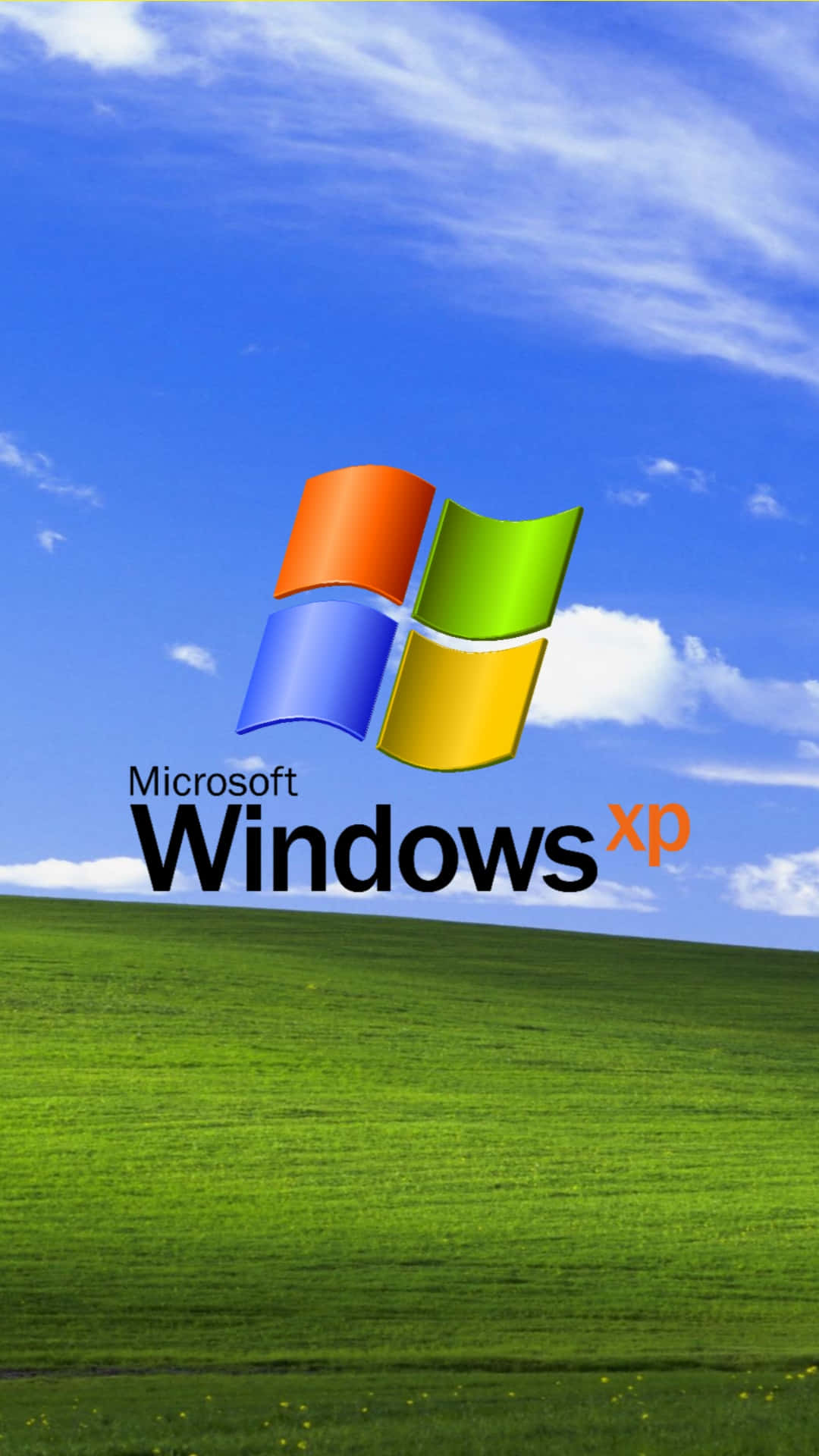 Windows Xp Logo 桌布 壁紙 — Windows XP 標誌漂浮在充滿活力的綠色田野上，下方是明亮的藍天和縷縷白雲。