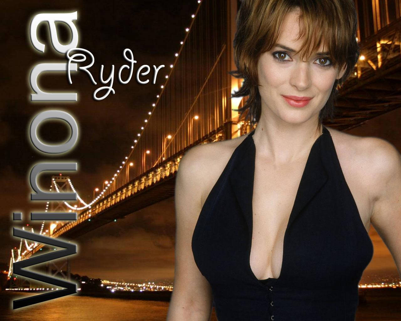 winona ryder 桌布 壁紙 — Winona Ryder 穿著黑色連衣裙，在發光的夜間橋樑背景和城市燈光下微笑。